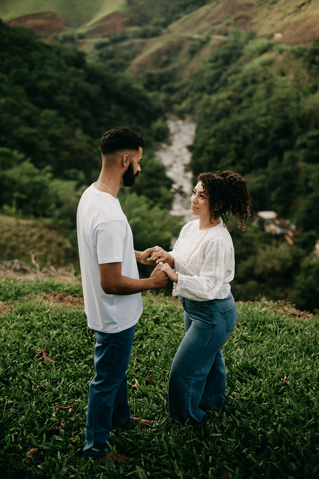 ensaio pré-casamento na serra do Sana, Macaé, com vista para montanhas e vegetação densa. Looks casuais jeans e branco.