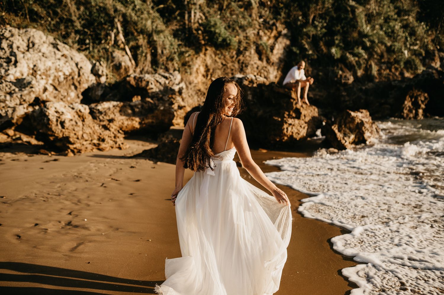Noiva correndo olhando pra traz com vestido esvoaçante na praia em Búzios - RJ