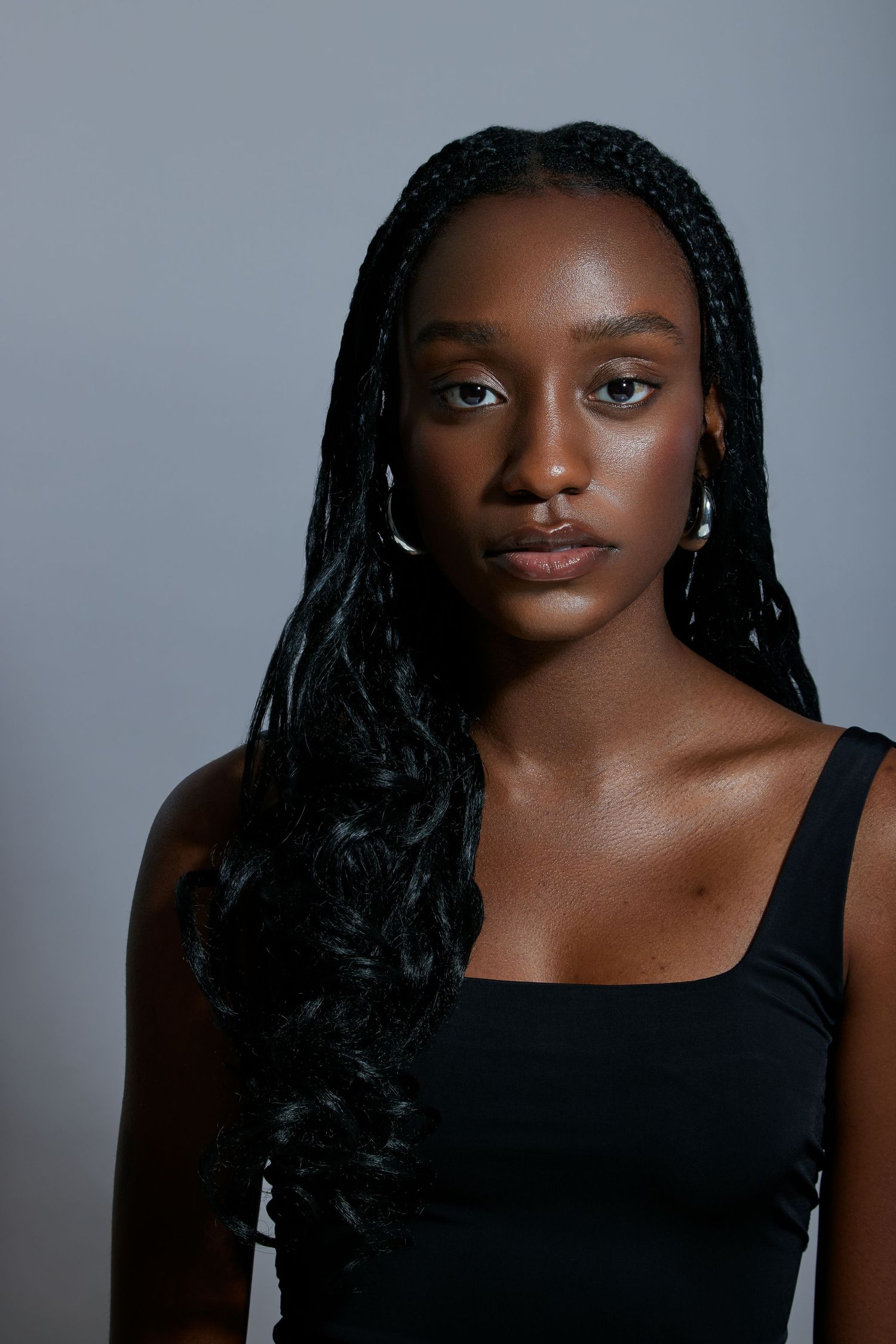 Portrait series showing close-up beauty shots against a gray background wearing a black top.