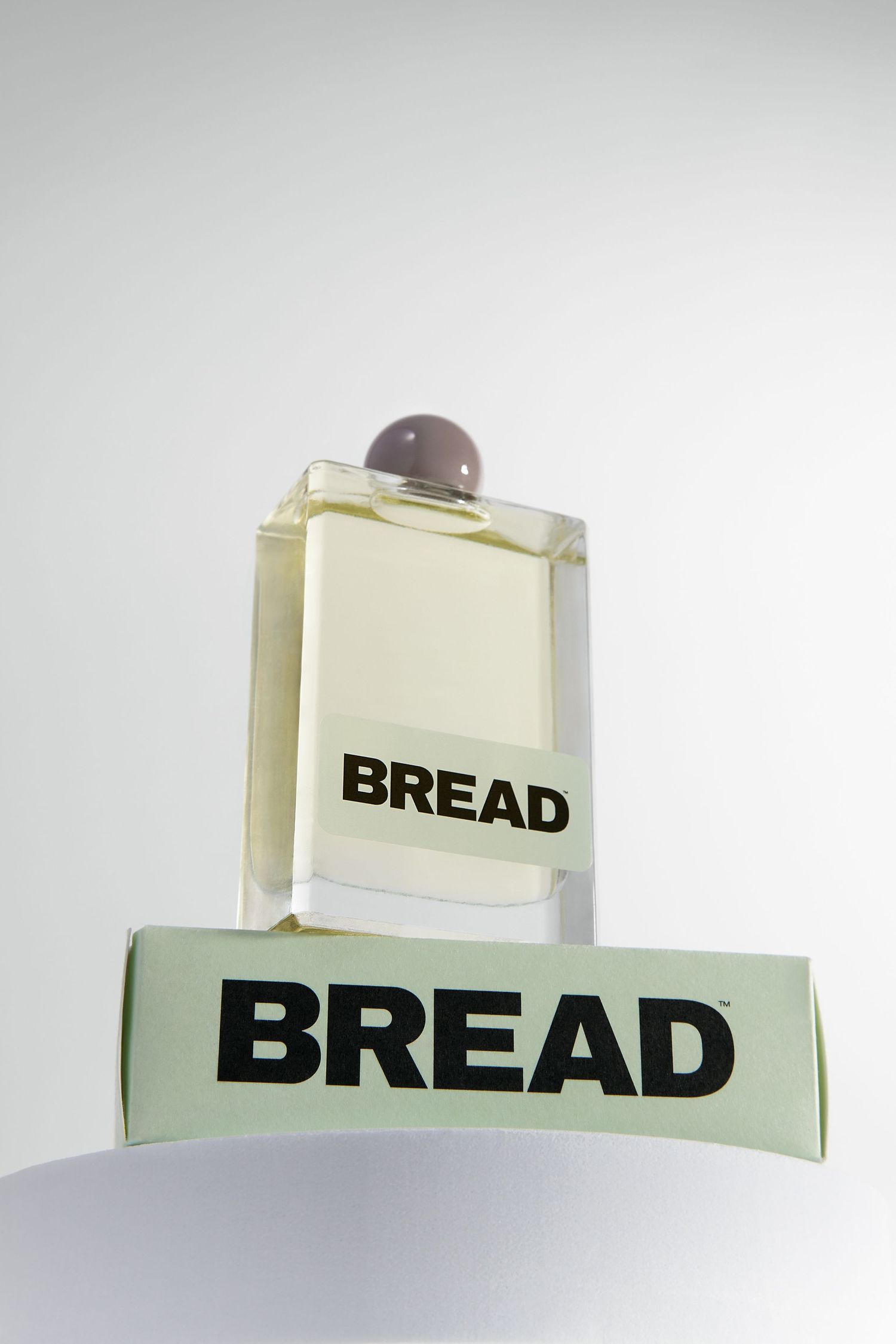 A minimalist sequence showing a retro-style cream-colored bread box with bold black lettering against a light background.