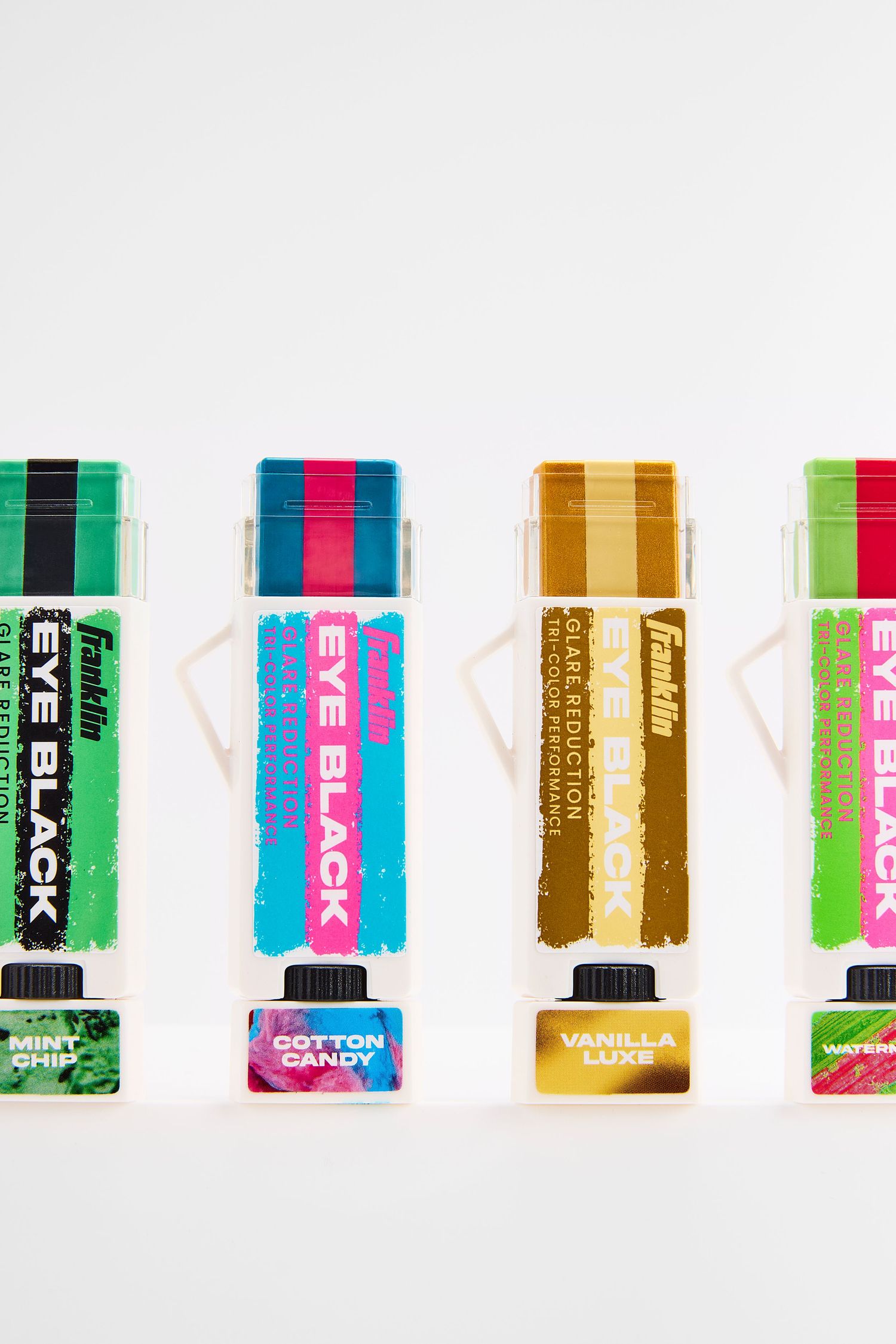 Colorful lineup of eyeblacks featuring vibrant stripes and modern geometric designs in pink, green, and gold tones.