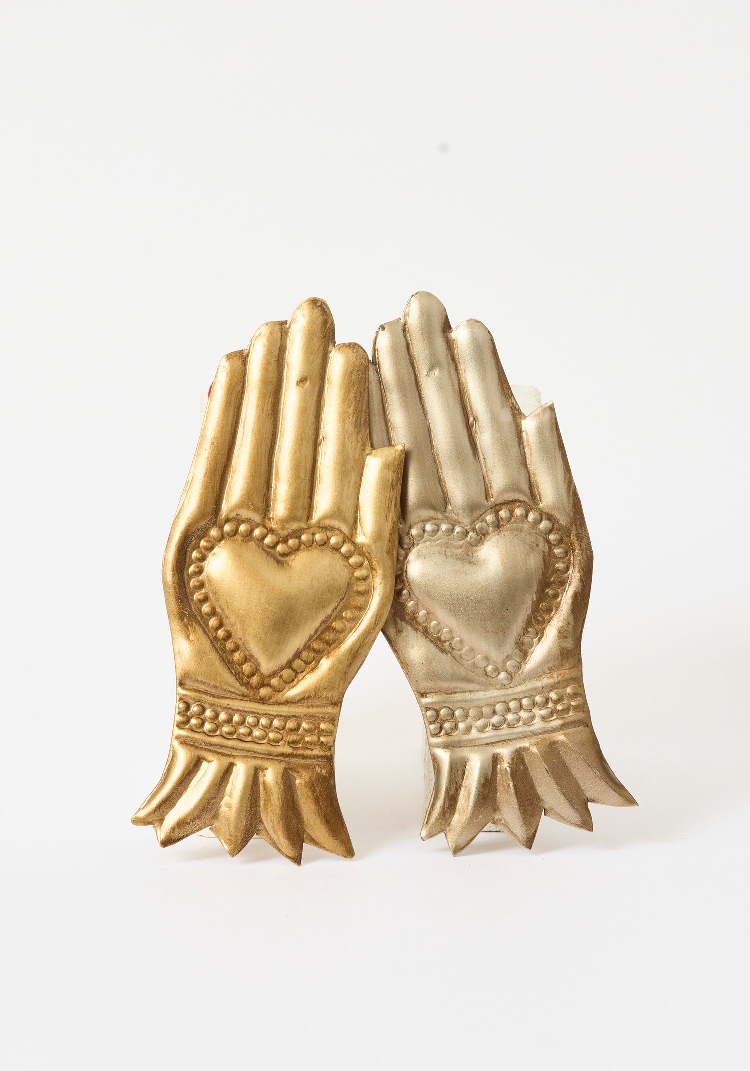 Gold decorative hands sculpture with heart motifs, perfect for home decor accent piece.