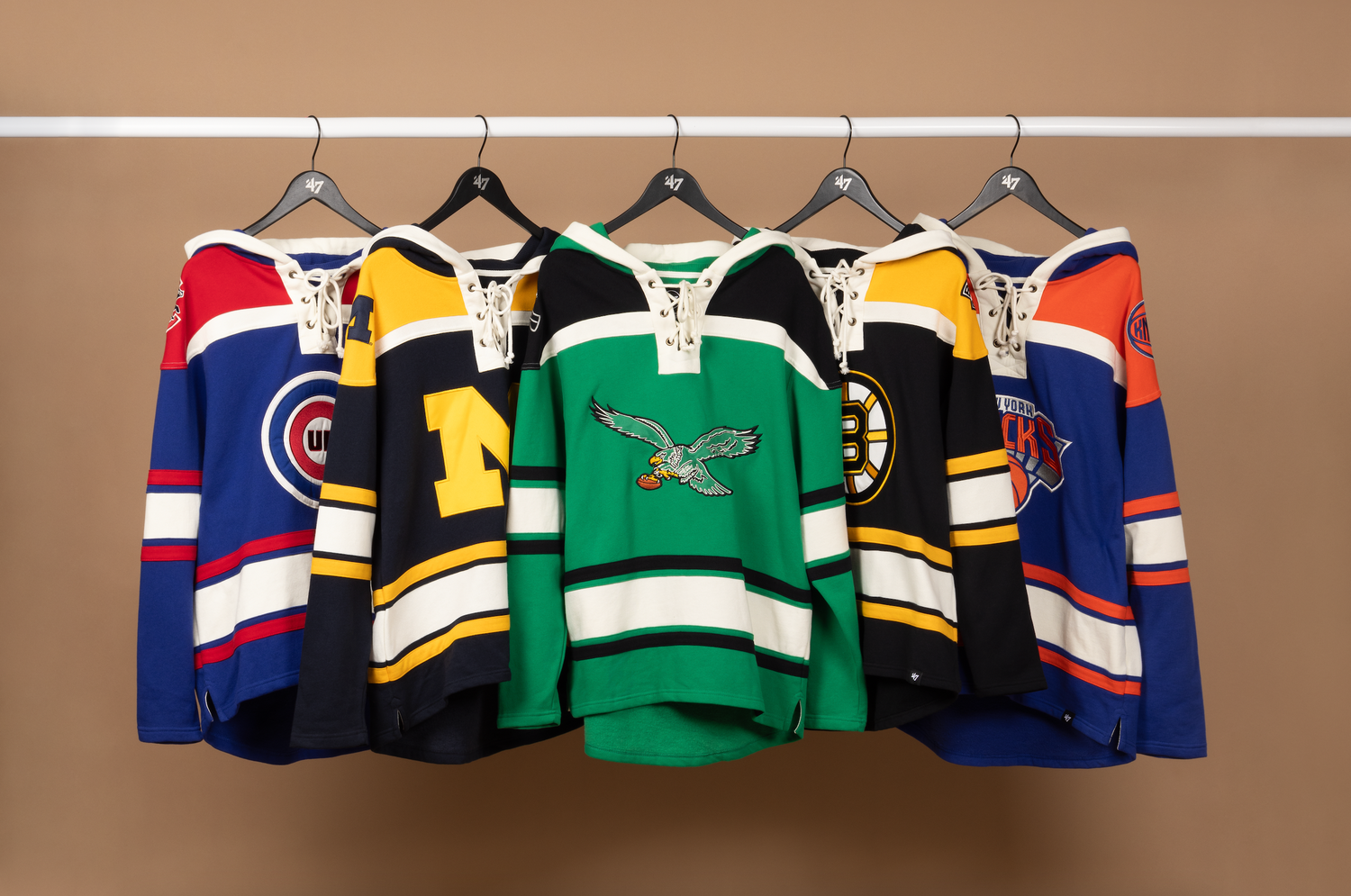 Hockey jerseys from multiple teams displayed on hangers including NHL teams like the Bruins, Rangers and North Stars.