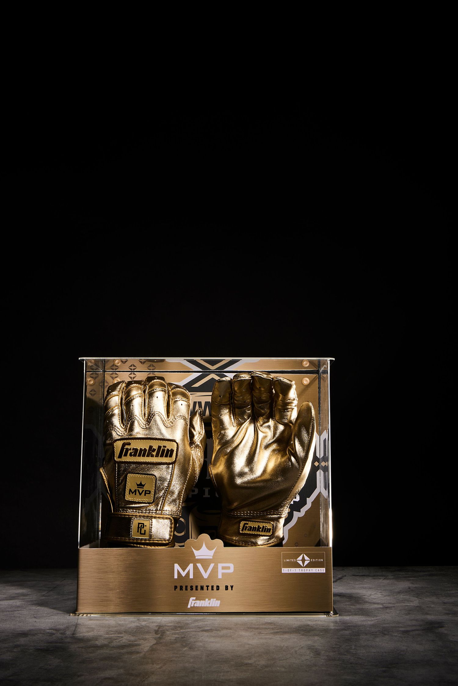 Gold metallic Franklin baseball gloves displayed in dramatic lighting on dark surface with MVP branding.