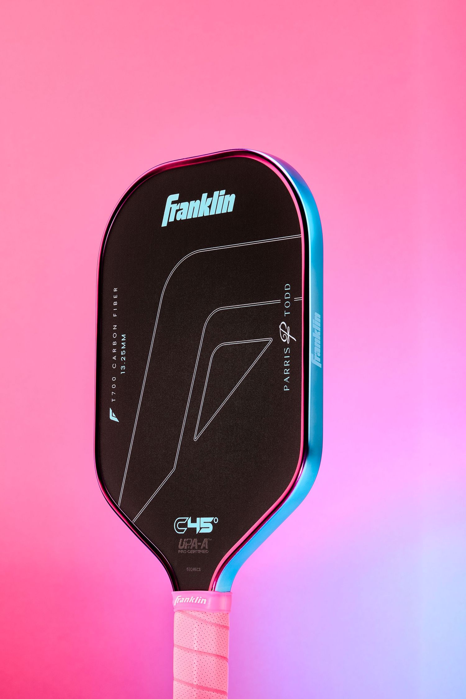 A black Franklin pickleball paddle with blue trim photographed against a pink gradient background.