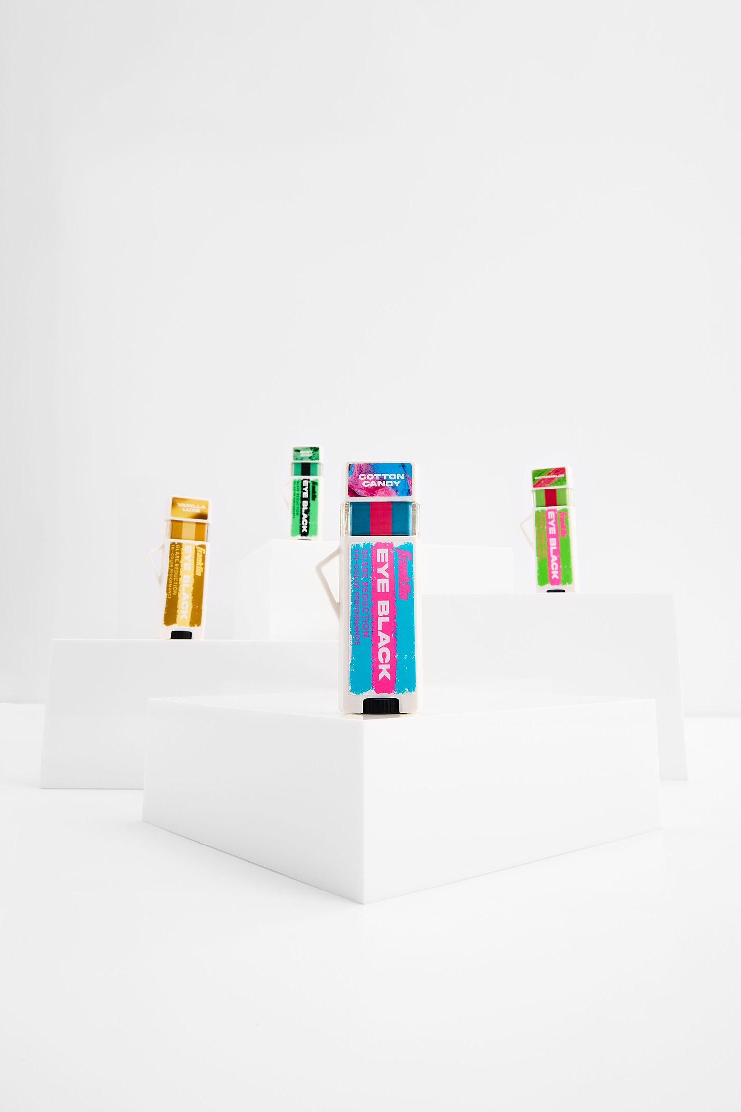 Minimalist photo series showing colorful baseball eyeblack arranged on white surfaces from different angles and perspectives.