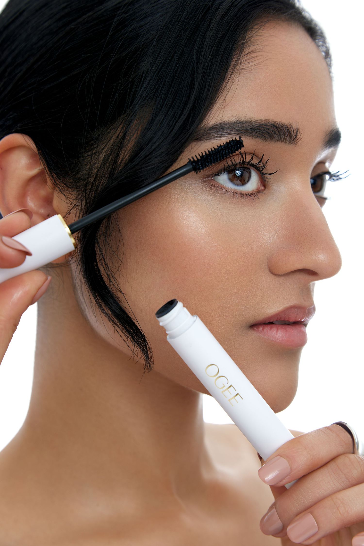 Close-up sequence showing application of mascara to eyelashes against white background.