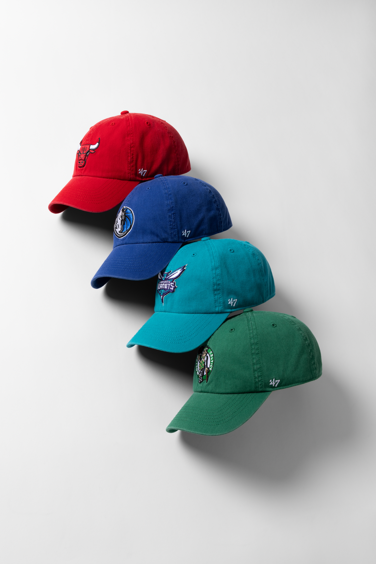Three baseball caps in red, blue, and green colors arranged in a diagonal line on a white background.