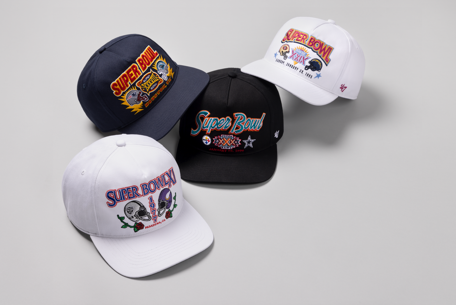 Collection of sports team baseball caps in black and white colors featuring team logos displayed on gray background.