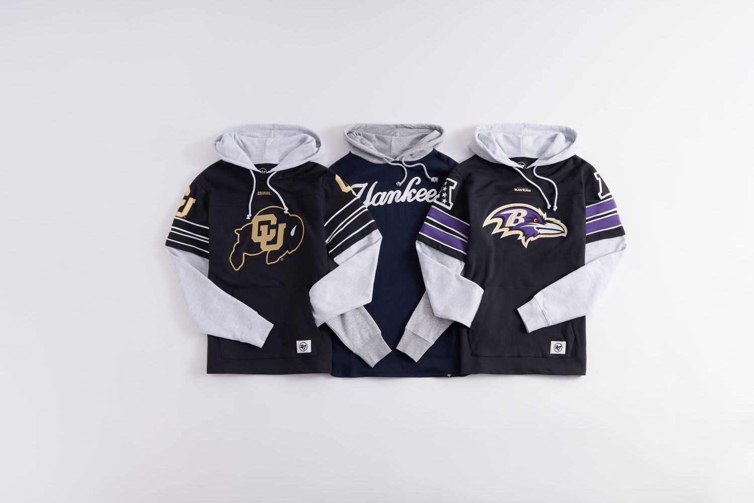 Three sports hoodies featuring Colorado Buffaloes, New York Yankees, and Baltimore Ravens team logos displayed side by side.