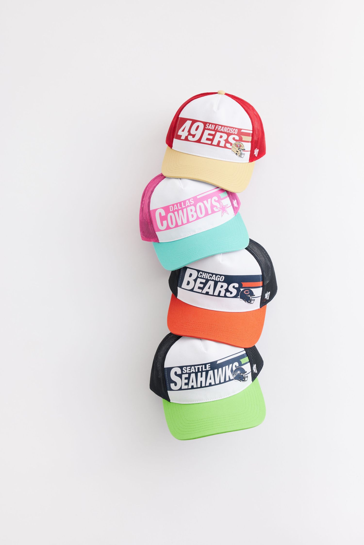 Collection of colorful sports team snapback hats including 49ers, Bears, and Seahawks arranged on white background.