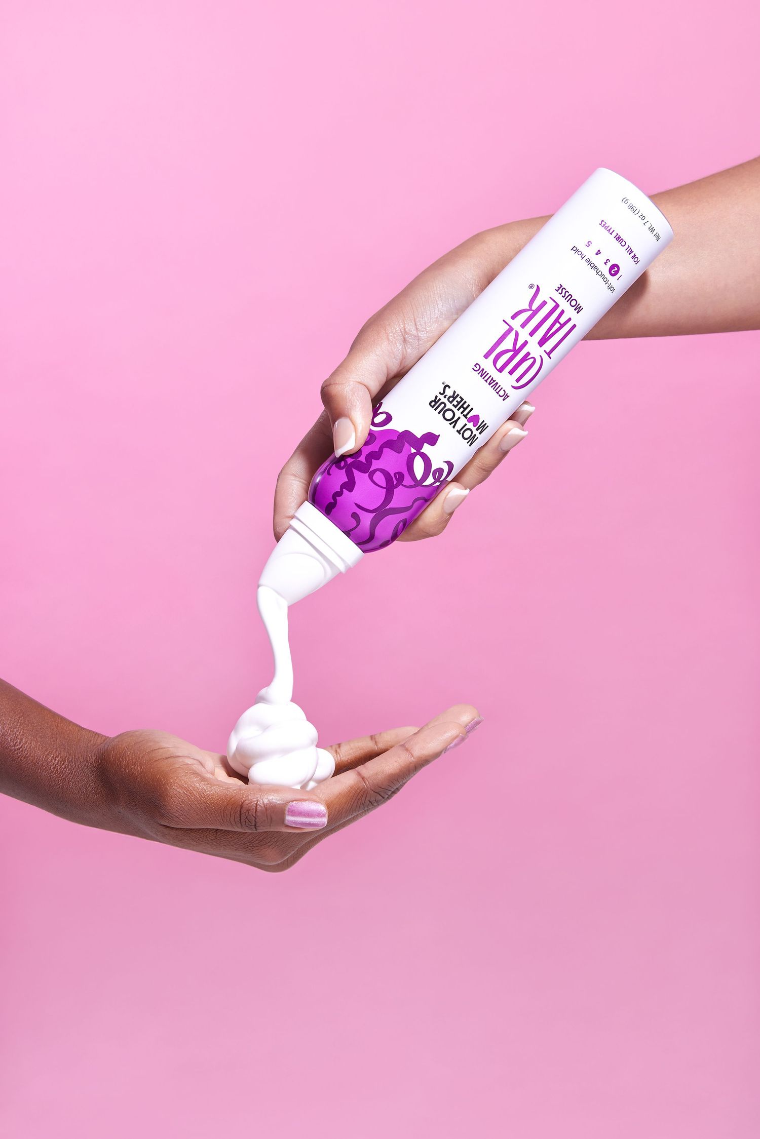 Hand pouring thick purple liquid from a white bottle against a pink background in a creative product photography series.