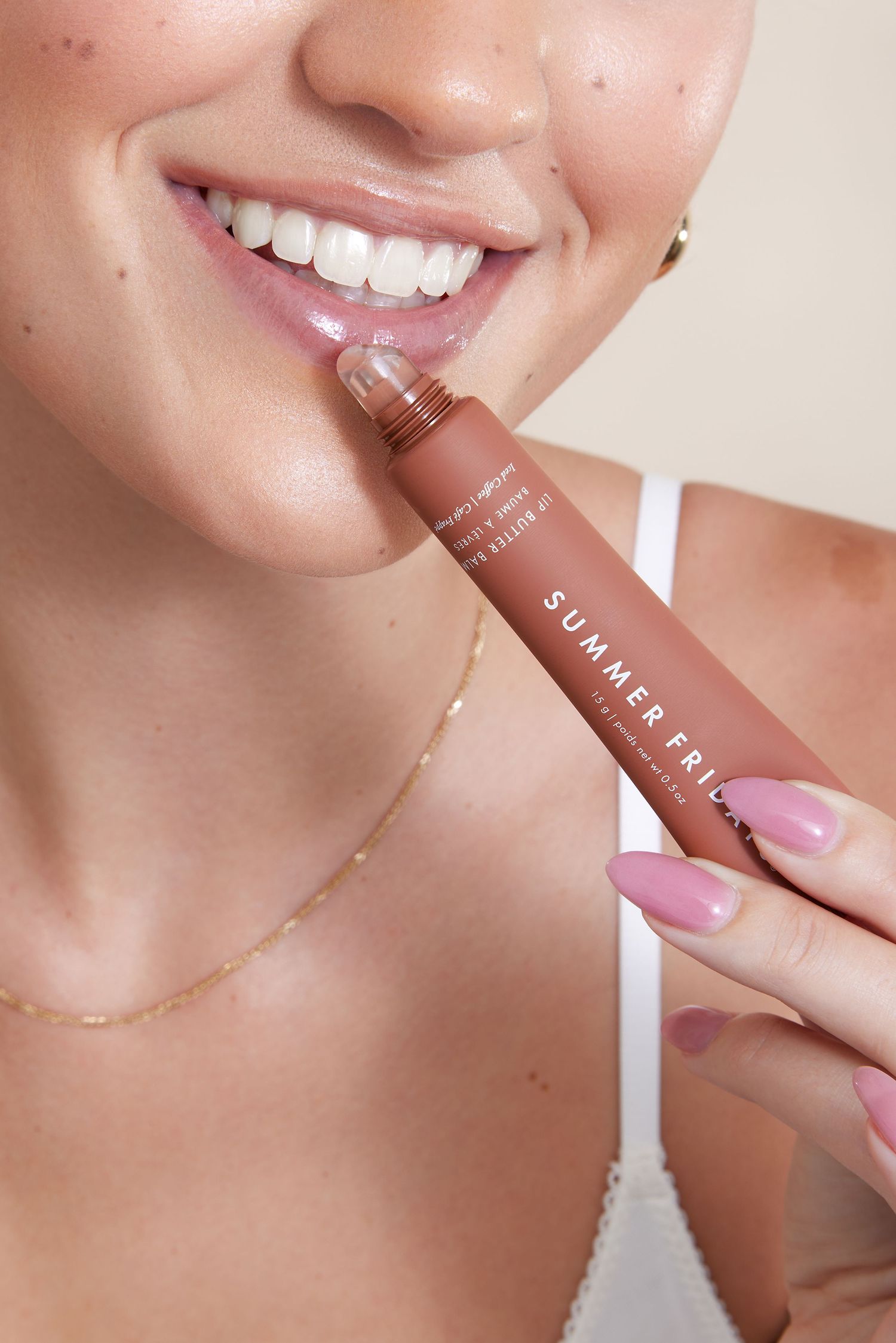 A series of close-up shots showing someone applying lip gloss with a glossy pink applicator wand.