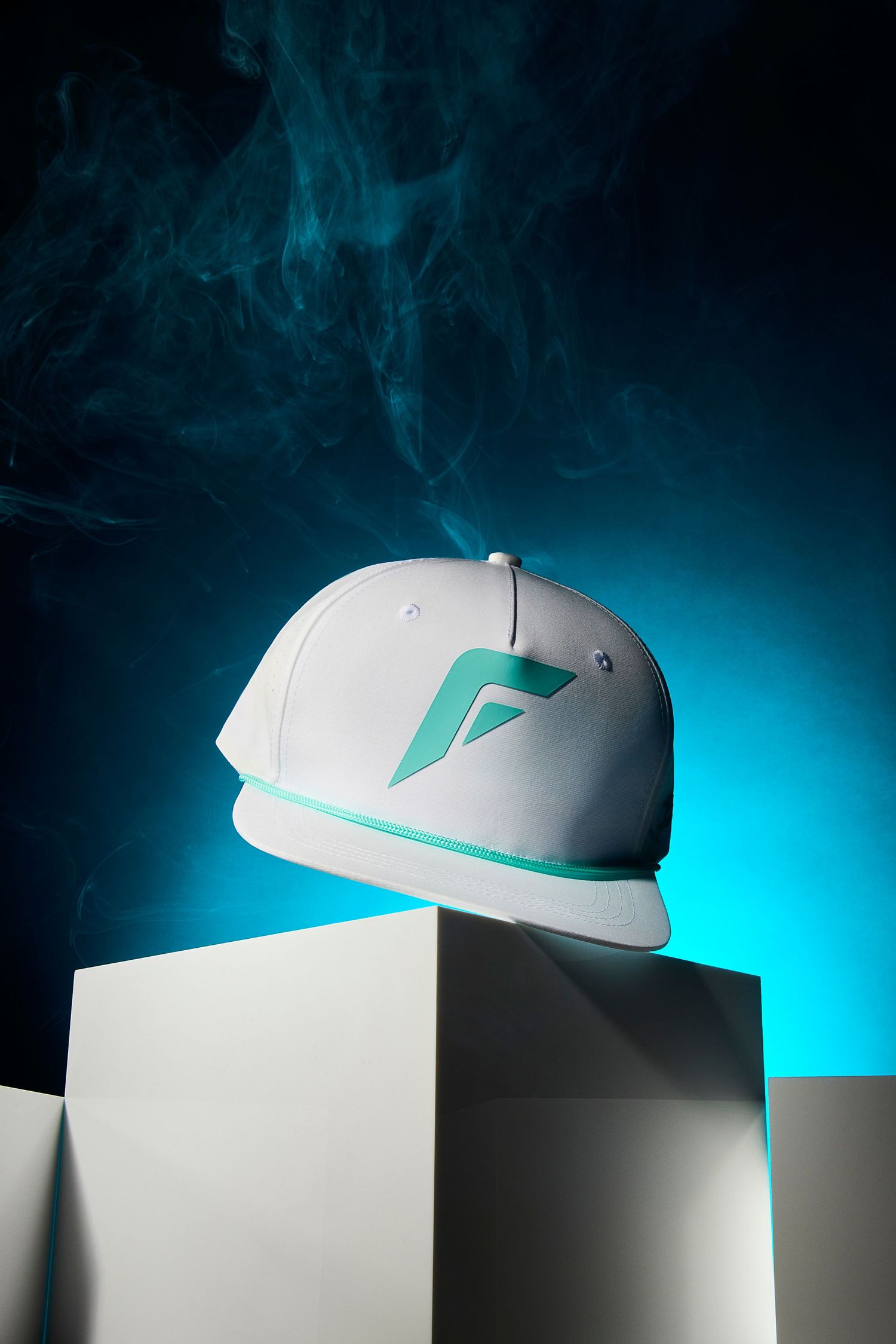 A white baseball cap with teal accents photographed in sequence against a dark background with dramatic blue lighting.