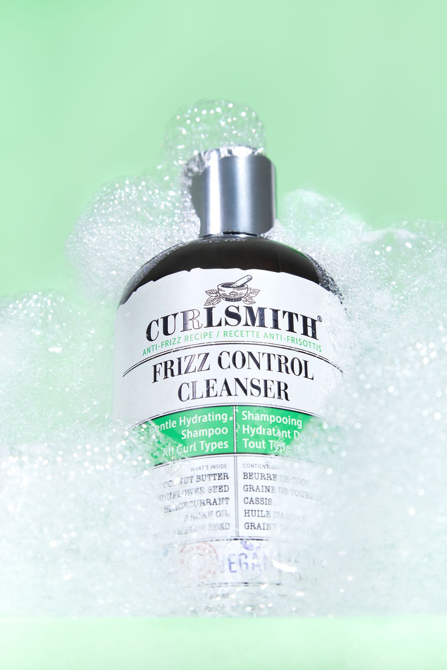 Stylish beauty product bottles with text overlay floating in bubbles against a mint green background.