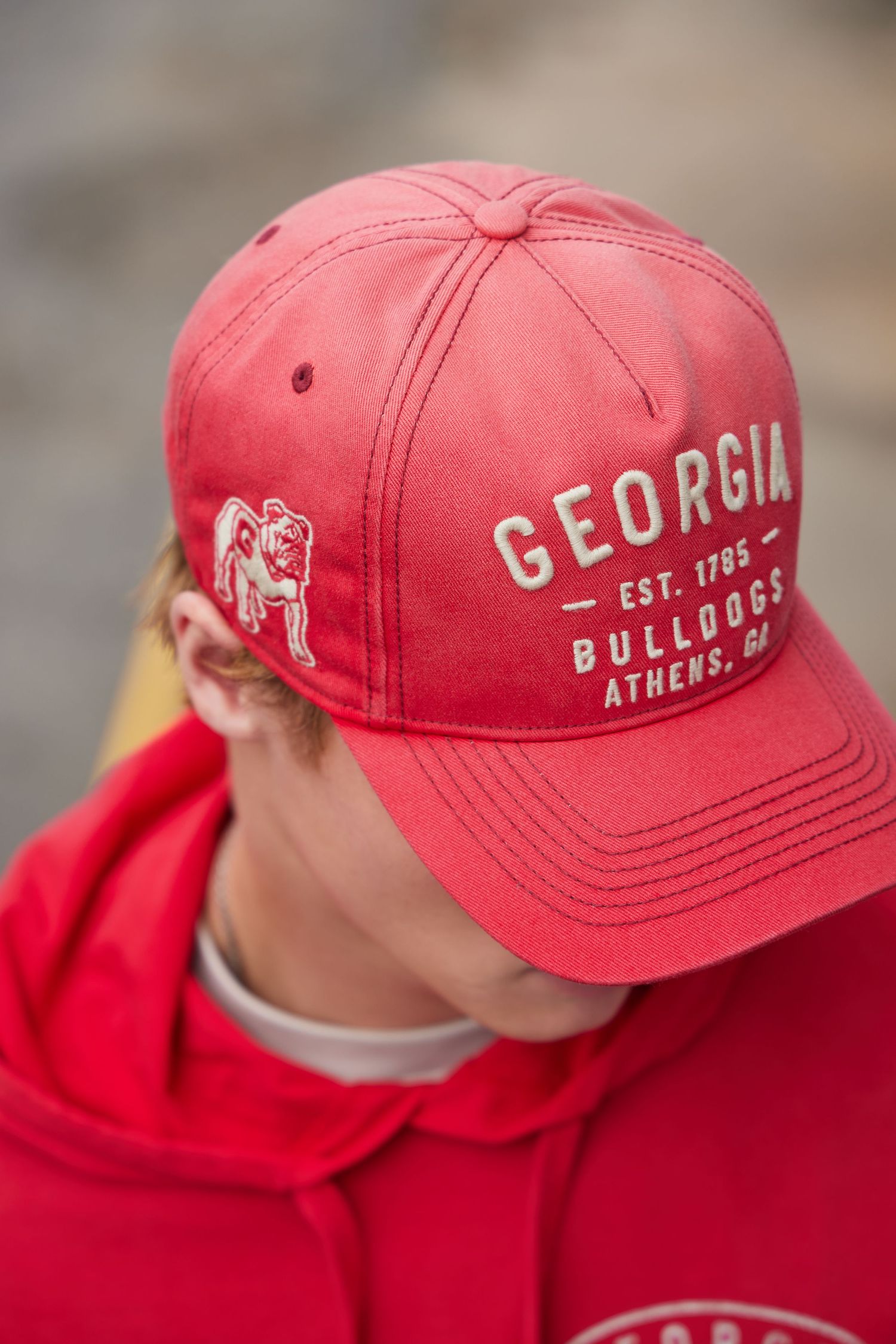 A red Georgia Bulldogs baseball cap shown from multiple angles displaying the team name and Athens text.