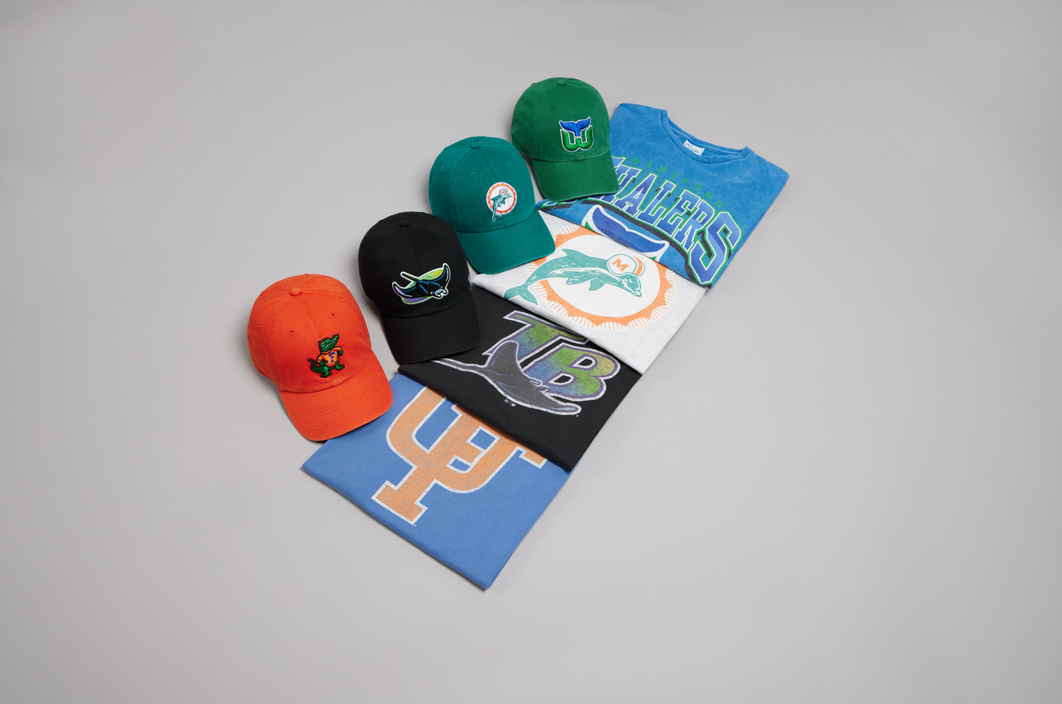 A collection of athletic apparel and accessories including hats, shirts, and shoes arranged on a light gray background.
