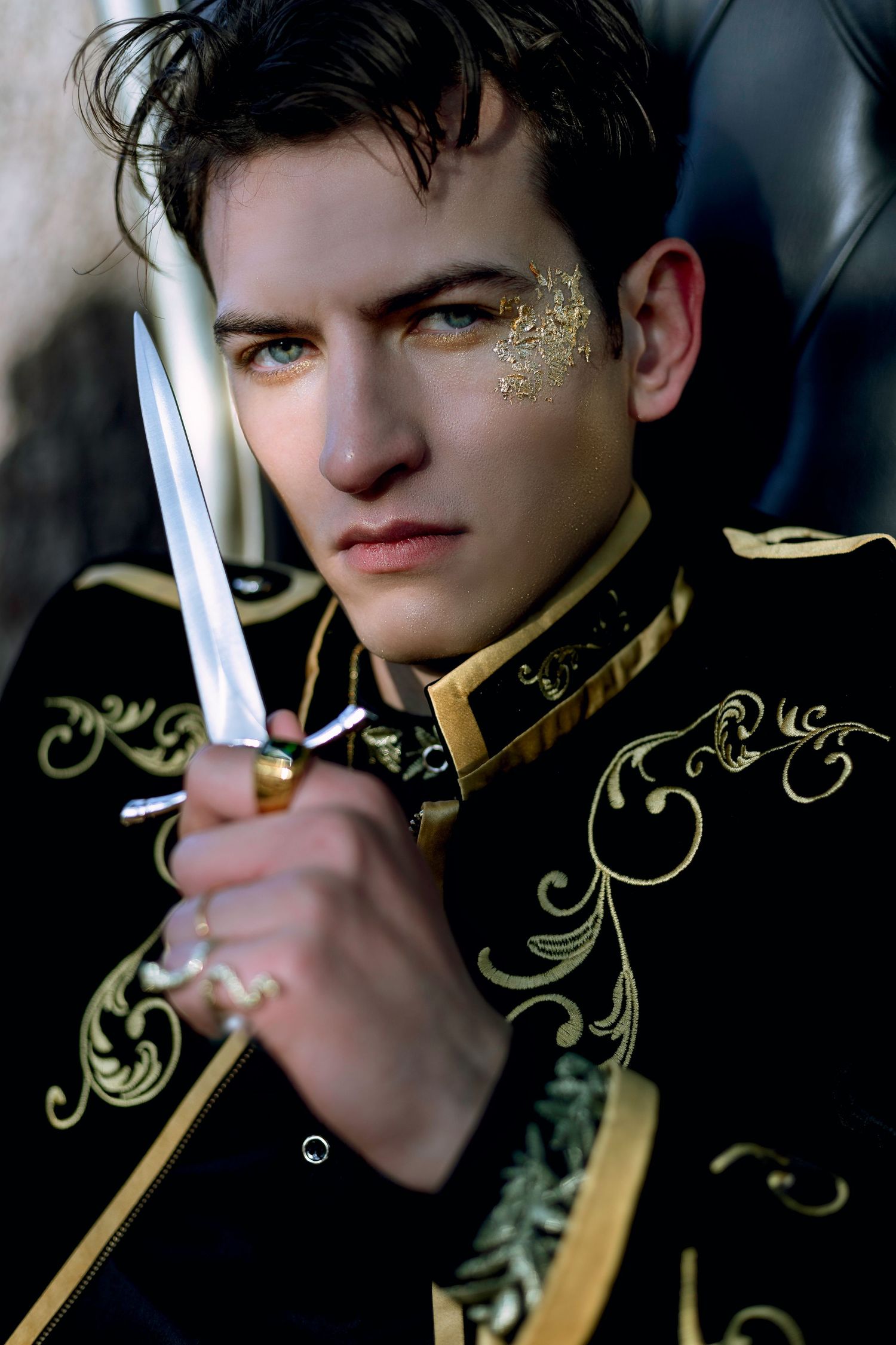 A series of four dark dramatic photos showing someone holding a glowing light sword against a black background with gold accents.
