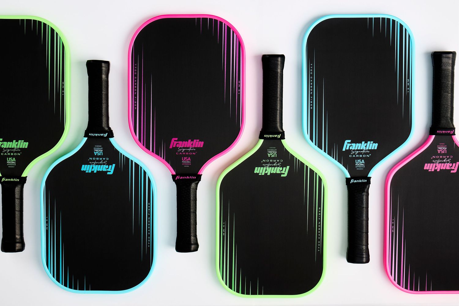 Neon blue, pink, and green Franklin Sports pickleball paddles against a white background with soft, minimal lighting.