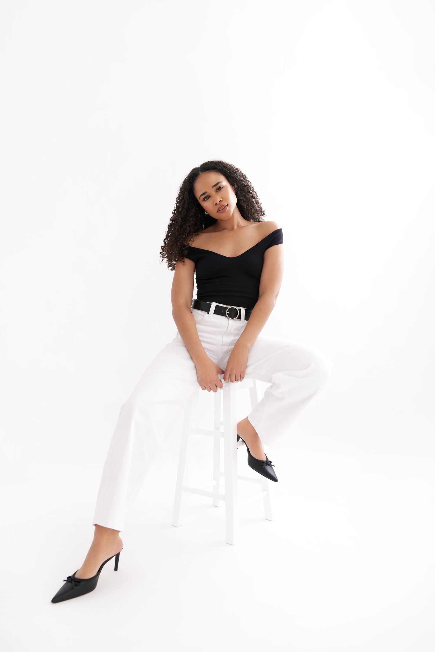 A figure in a black top and white skirt poses gracefully in three different positions against a white backdrop.