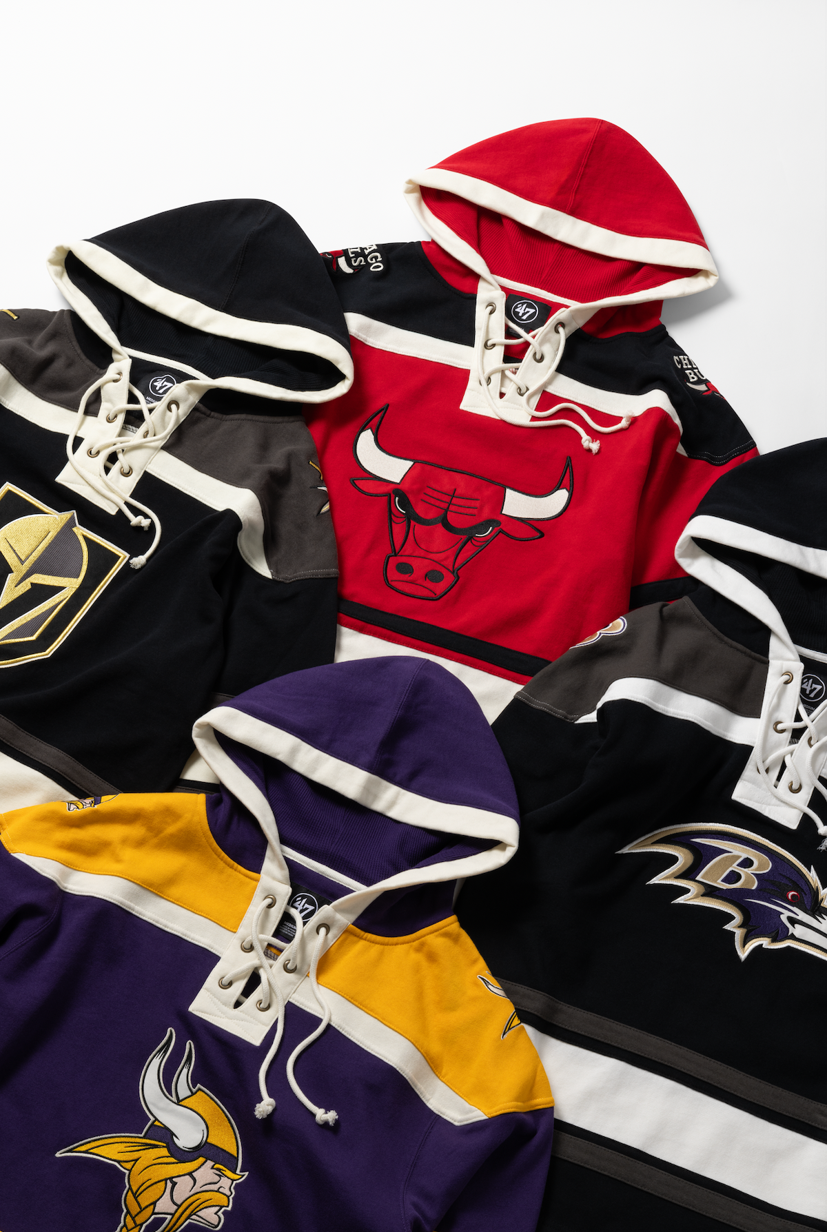 Collection of NHL hockey jerseys featuring team logos including Bulls, Vikings, and other professional sports teams laid flat.