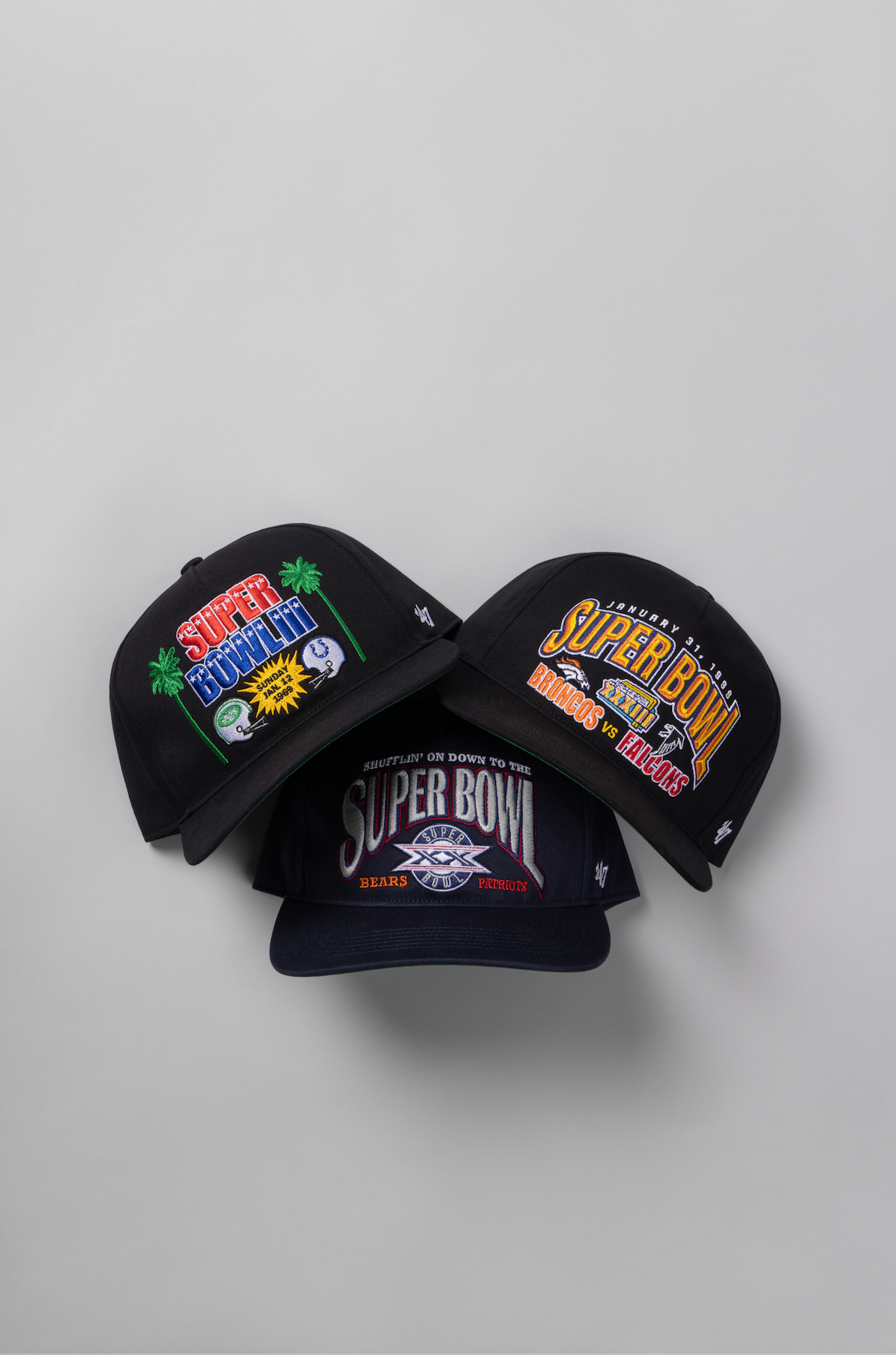 Vintage Super Bowl snapback hats from different years displayed in a row on a light gray background.