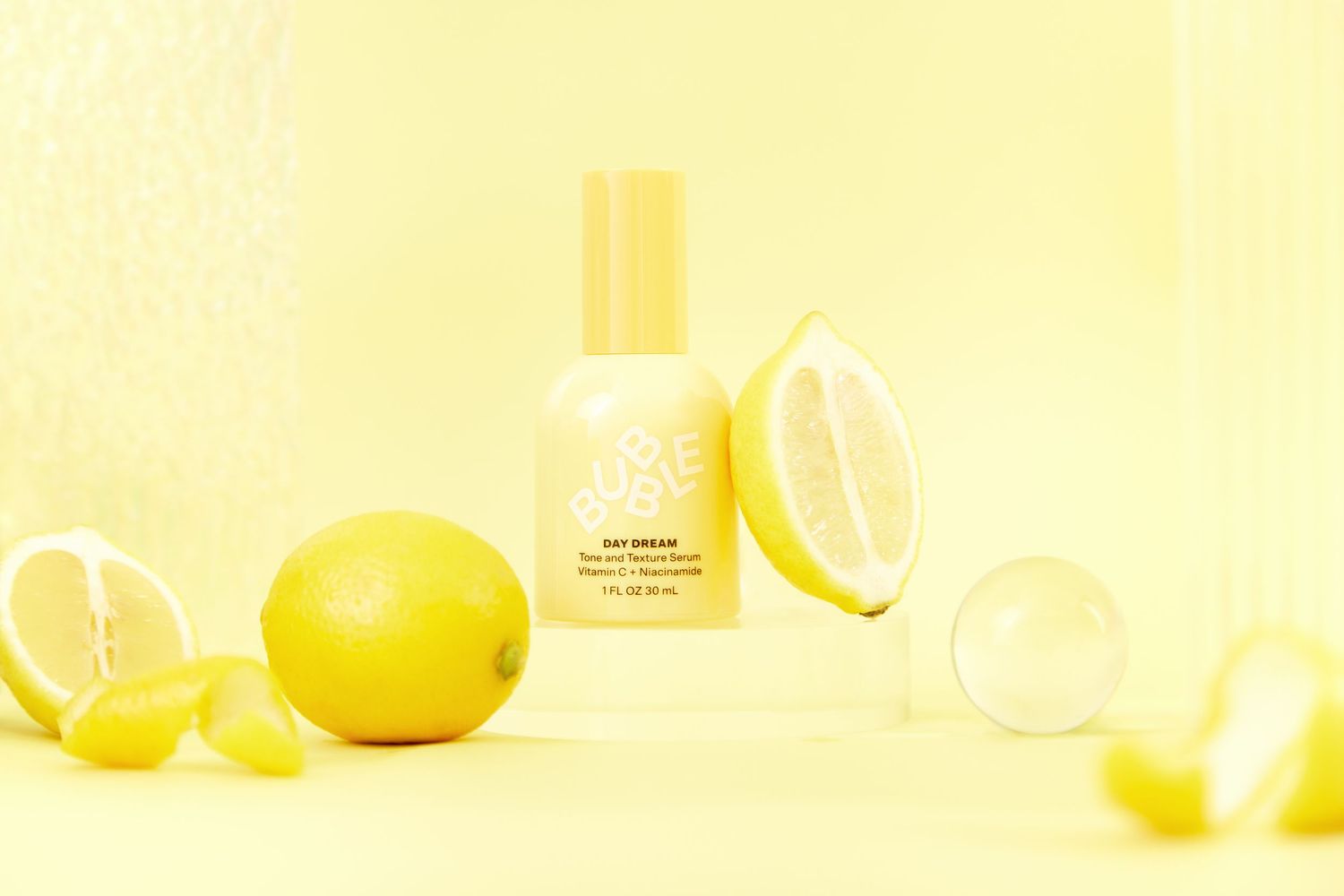 Fresh yellow lemons and citrus slices arranged on a bright yellow background with glass jars and bottles.