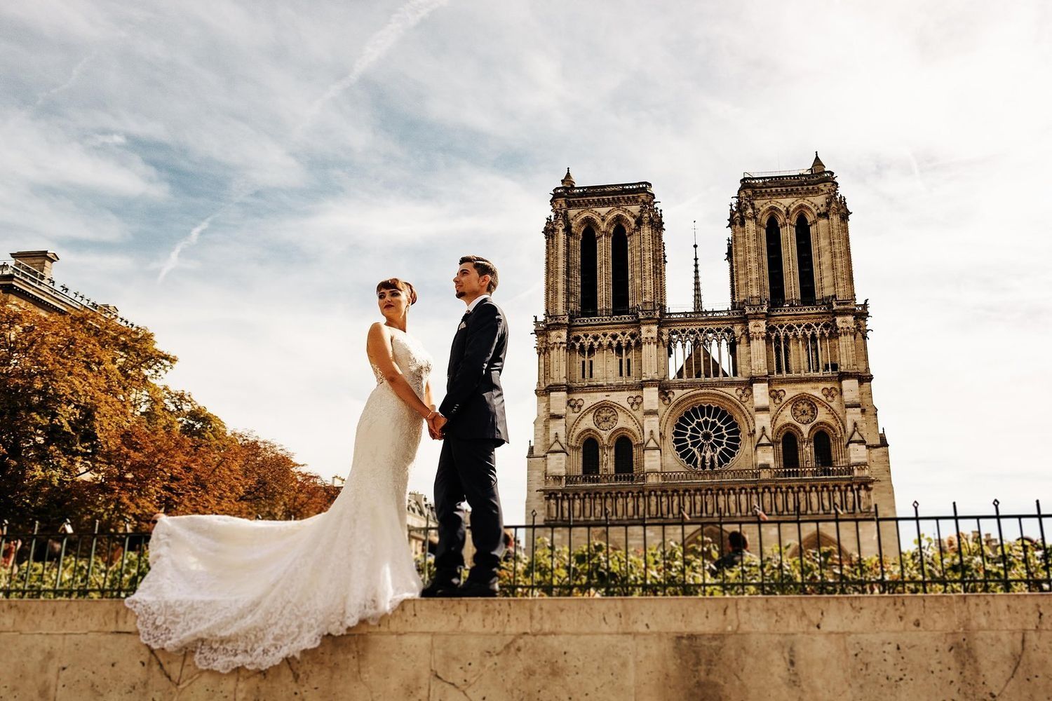 marisa y cristian compartiendo un momento de paz frente a la fachada gotica de la catedral de notre dame de paris