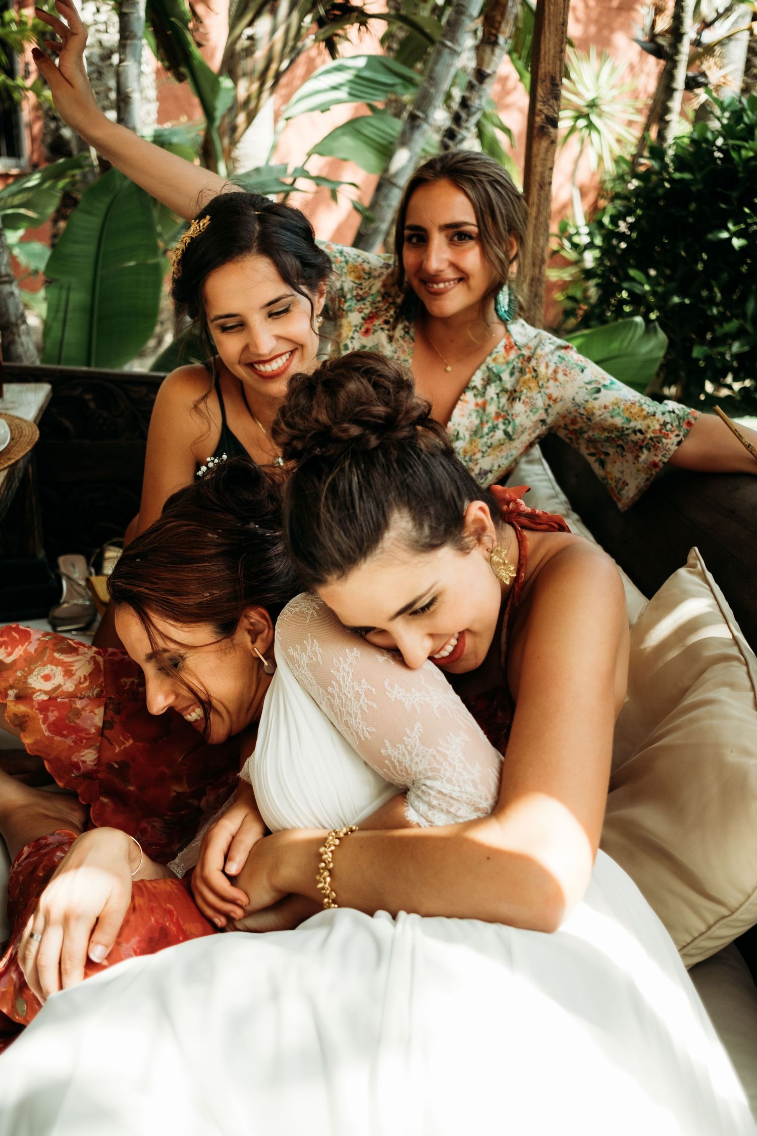 Miriam tumbada en cama balinesa con las invitadas de su boda, color y luz natural en Tarifa
