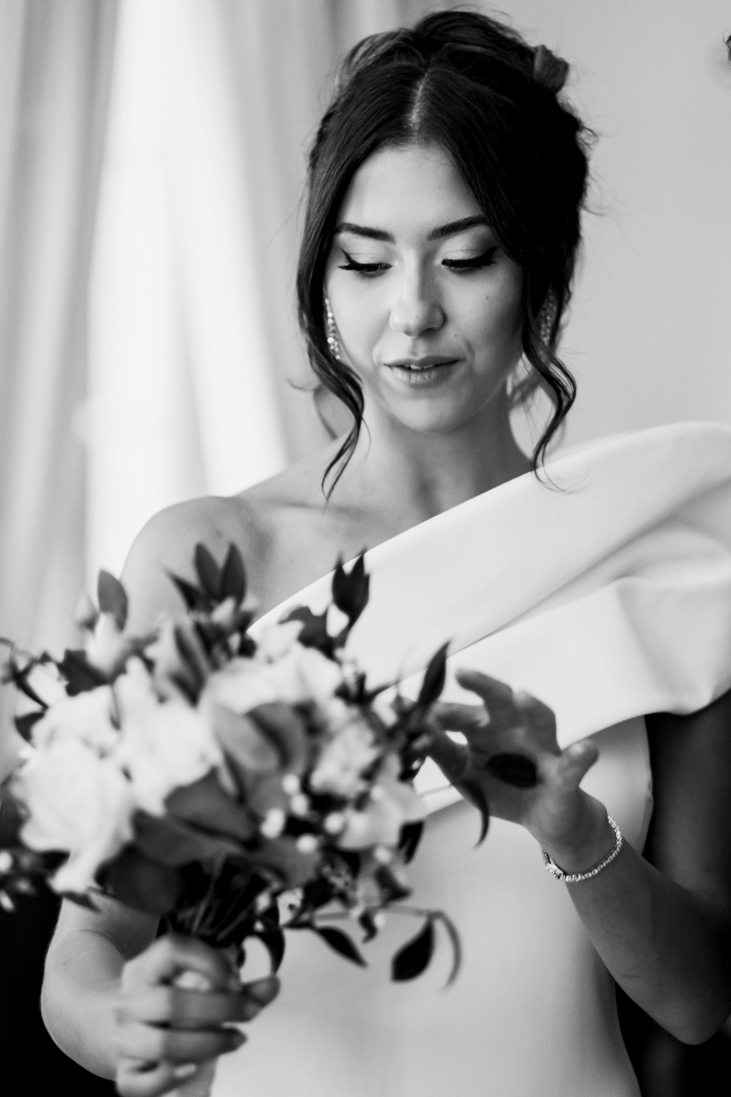 Close-up of bridal bouquet with white flowers against light background.