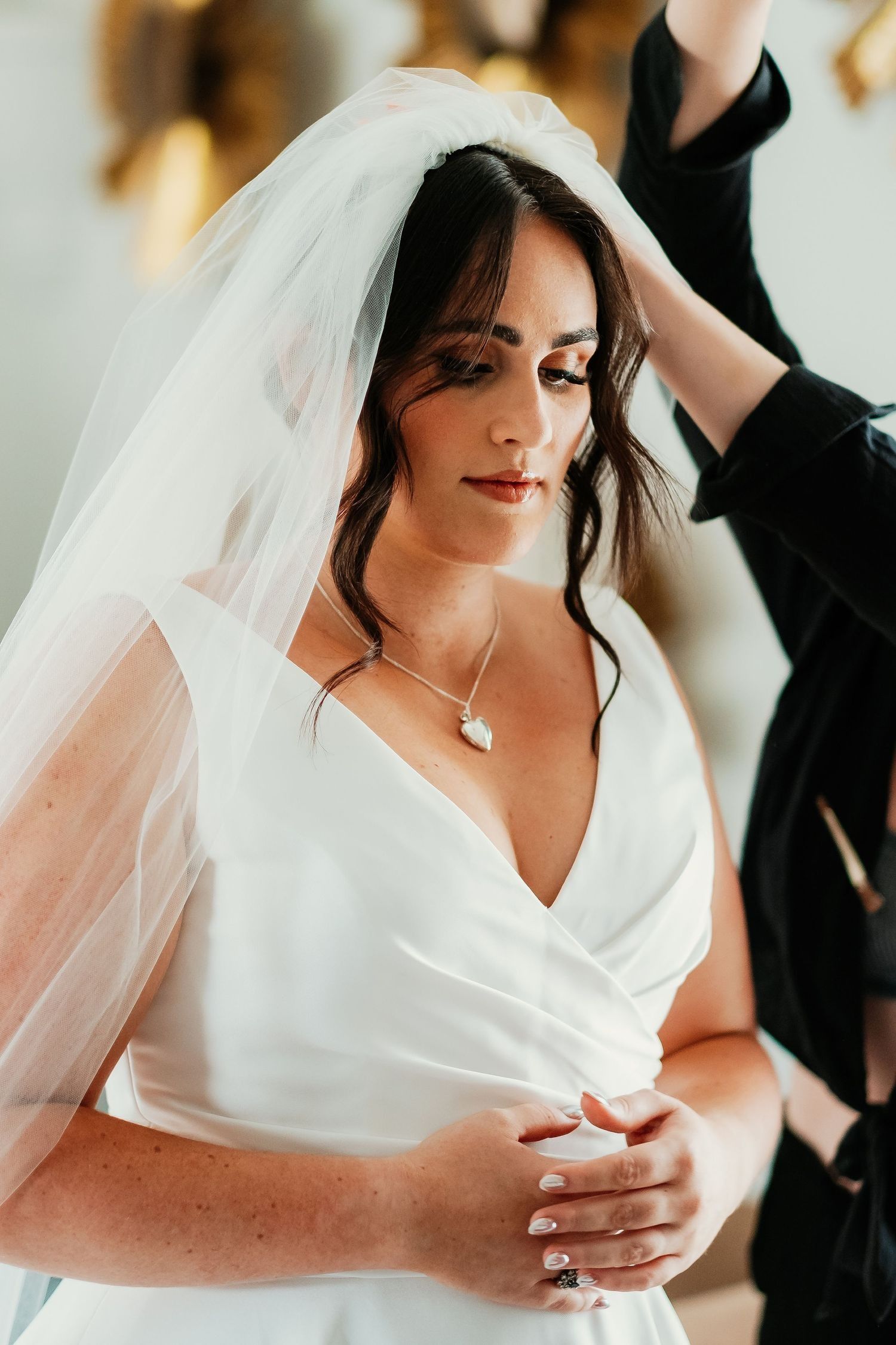 Madre de la novia ayudando a Jade con el velo del vestido de novia