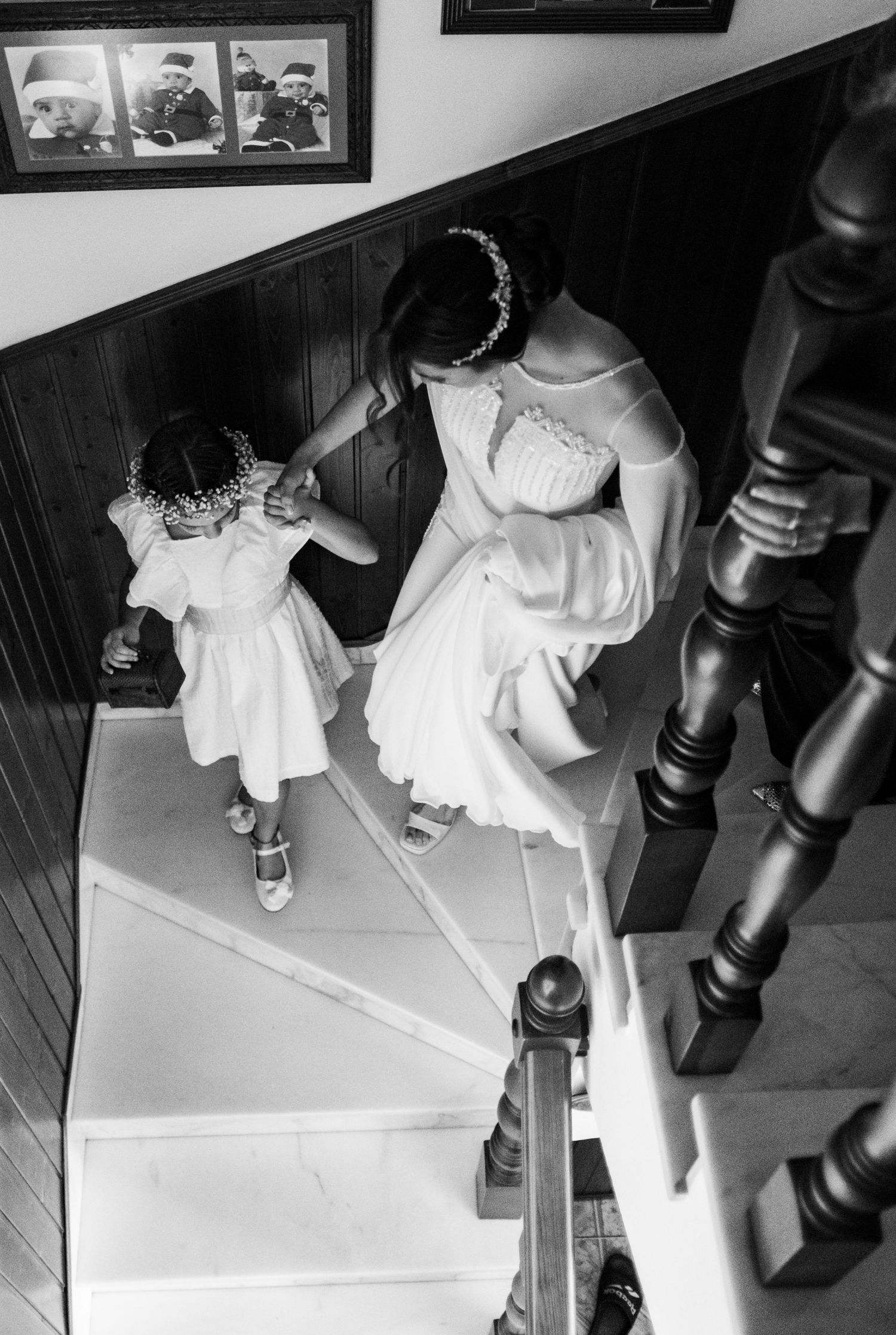 La novia bajando las escaleras de la mano de una de las damas, fotografia documental en blanco y negro