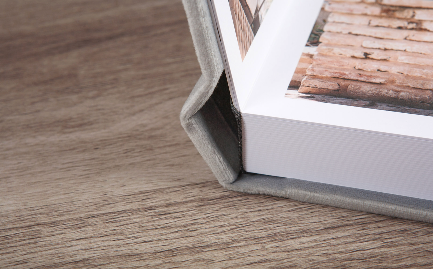 Detalle de encuadernación artesanal en lino natural y grabado de nombres personalizado en álbum de boda de lujo