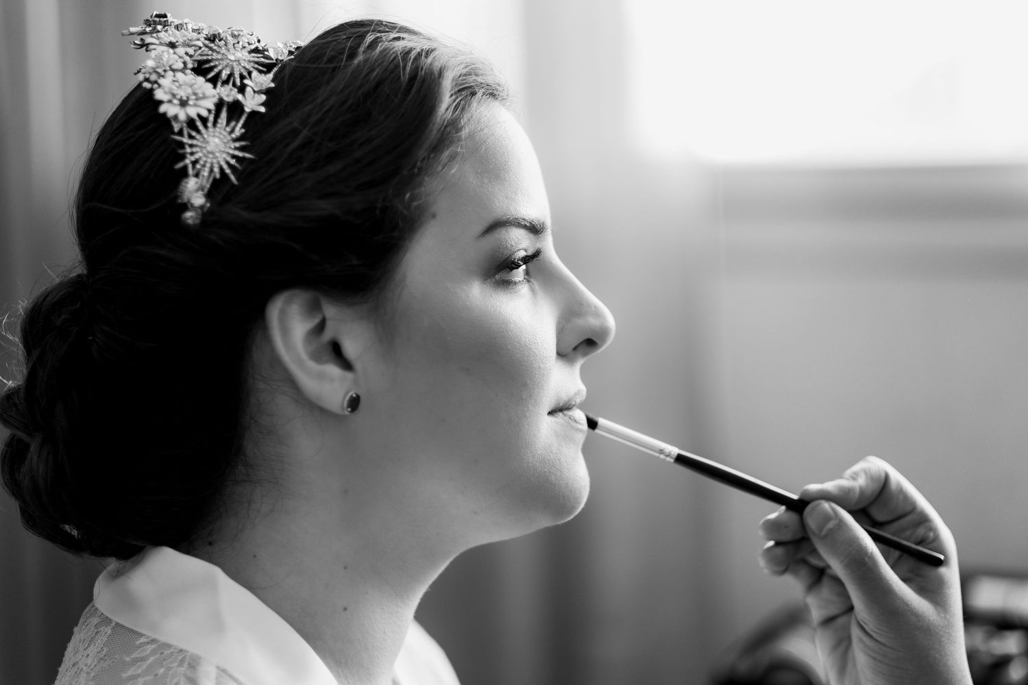 Retrato de Eli maquillándose, maquillaje natural para novias en Granada