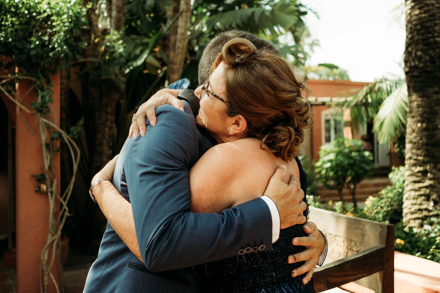 Abrazo del novio Andrés con su suegra en los jardines del Hotel en Tarifa