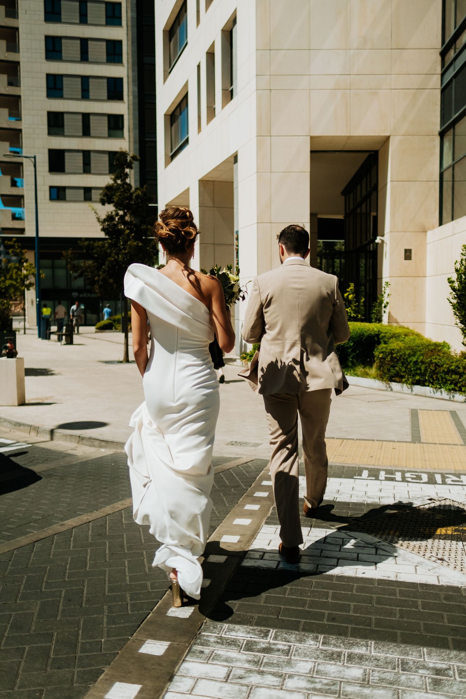 A sequence showing a person in a white dress falling down on stone pavement while another person in gray looks on.