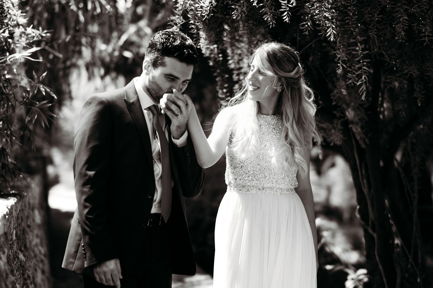 Groom kissing bride hand tender moment black and white photo Alameda Gardens Gibraltar