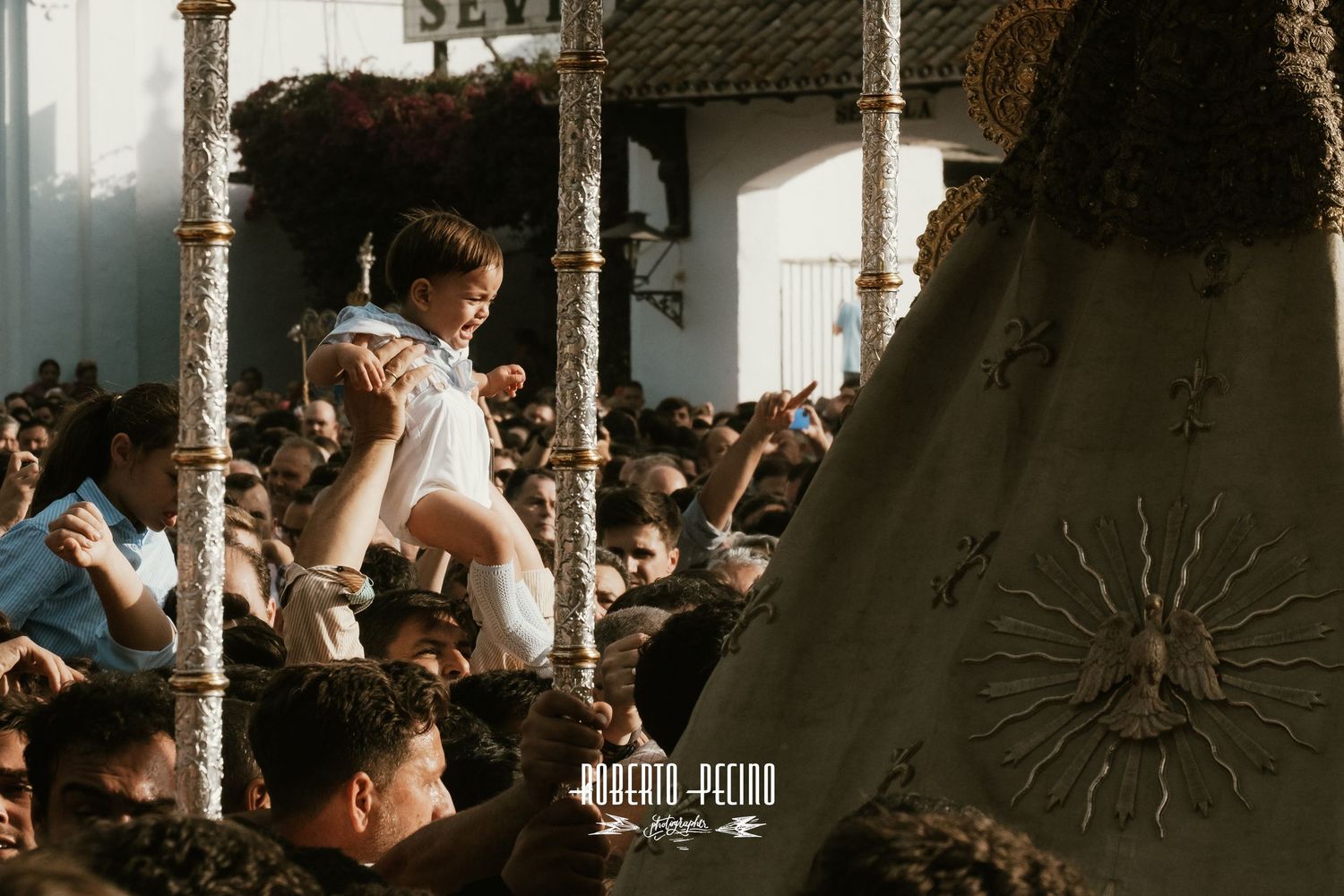 Fotografía documental procesión Rocío 2026, Niña llevada a las andas de la virgen, Roberto Pecino Fotógrafo, estética editorial.