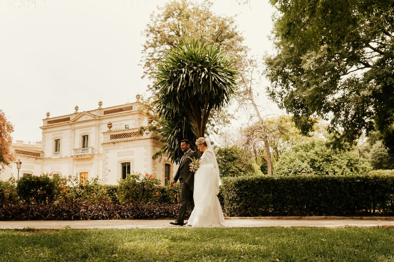 Perspectiva cinematográfica de la pareja paseando por los jardines en Bodega Sánchez Romate, Inma y Juanfri, Roberto Pecino
