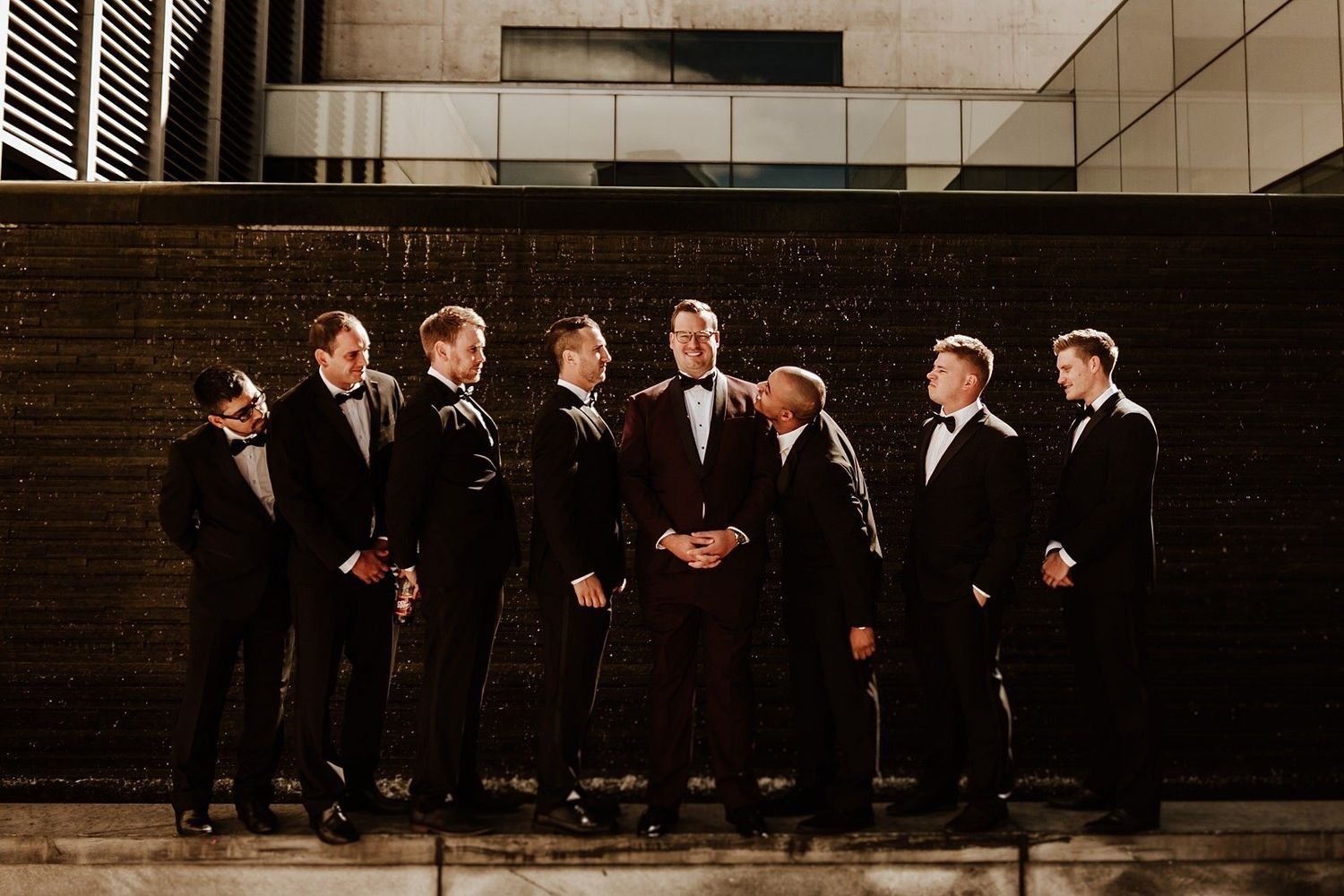 Groom and best men with modern Michigan architecture in the background