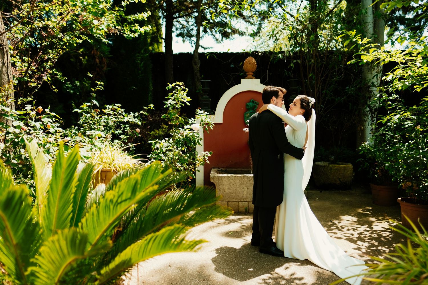 Mirada de complicidad de los novios con arquitectura andaluza de fondo