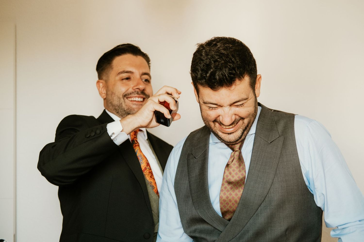 Amigo perfumando al novio en momento gracioso y espontaneo, Roberto Pecino fotografo en Jerez