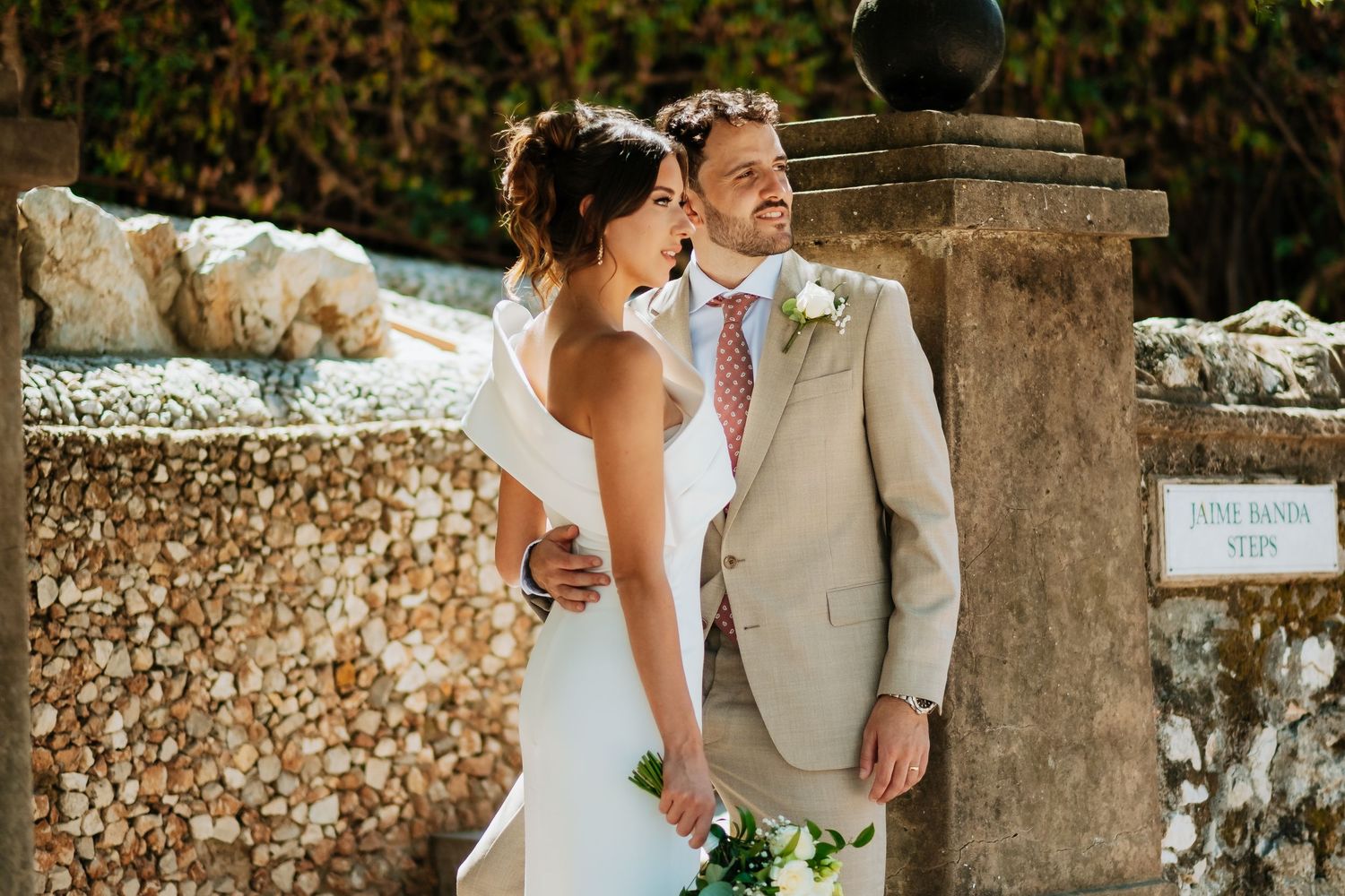 Romantic wedding photography session in garden setting with stone architecture.