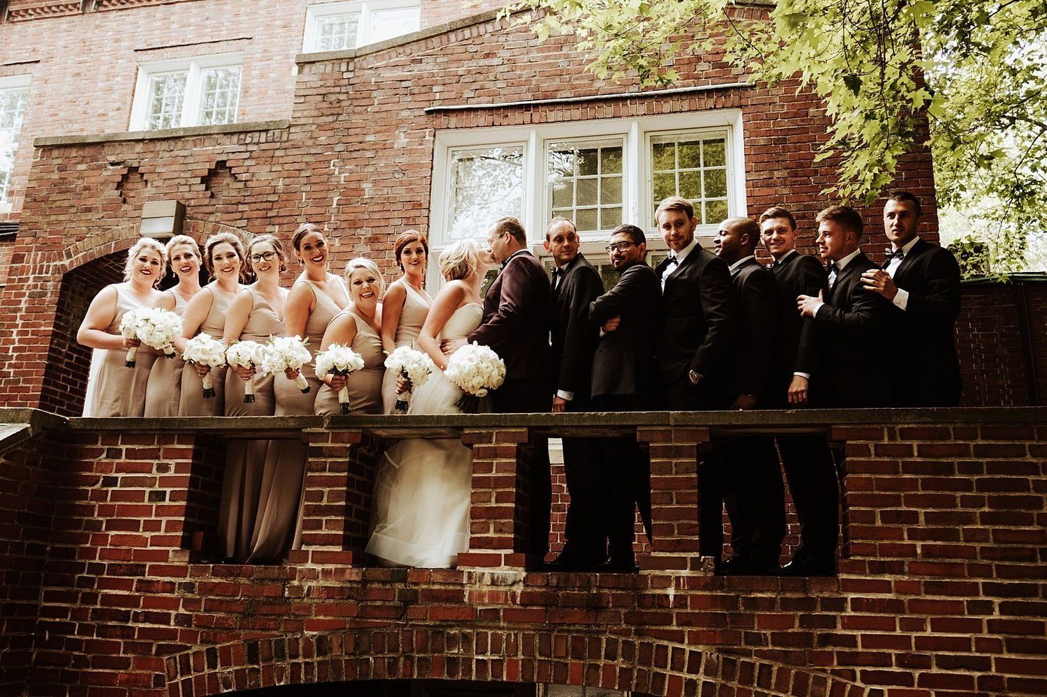 The wedding party posing in front of a majestic historic building facade in Grand Rapids
