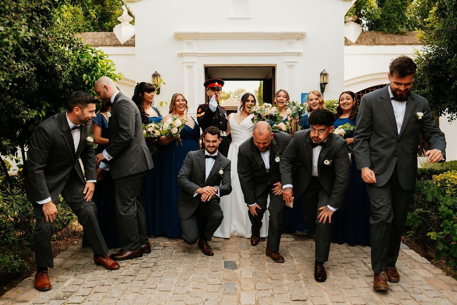 Fotografía de grupo de invitados con los novios en uno de los rincones de Finca Monasterio