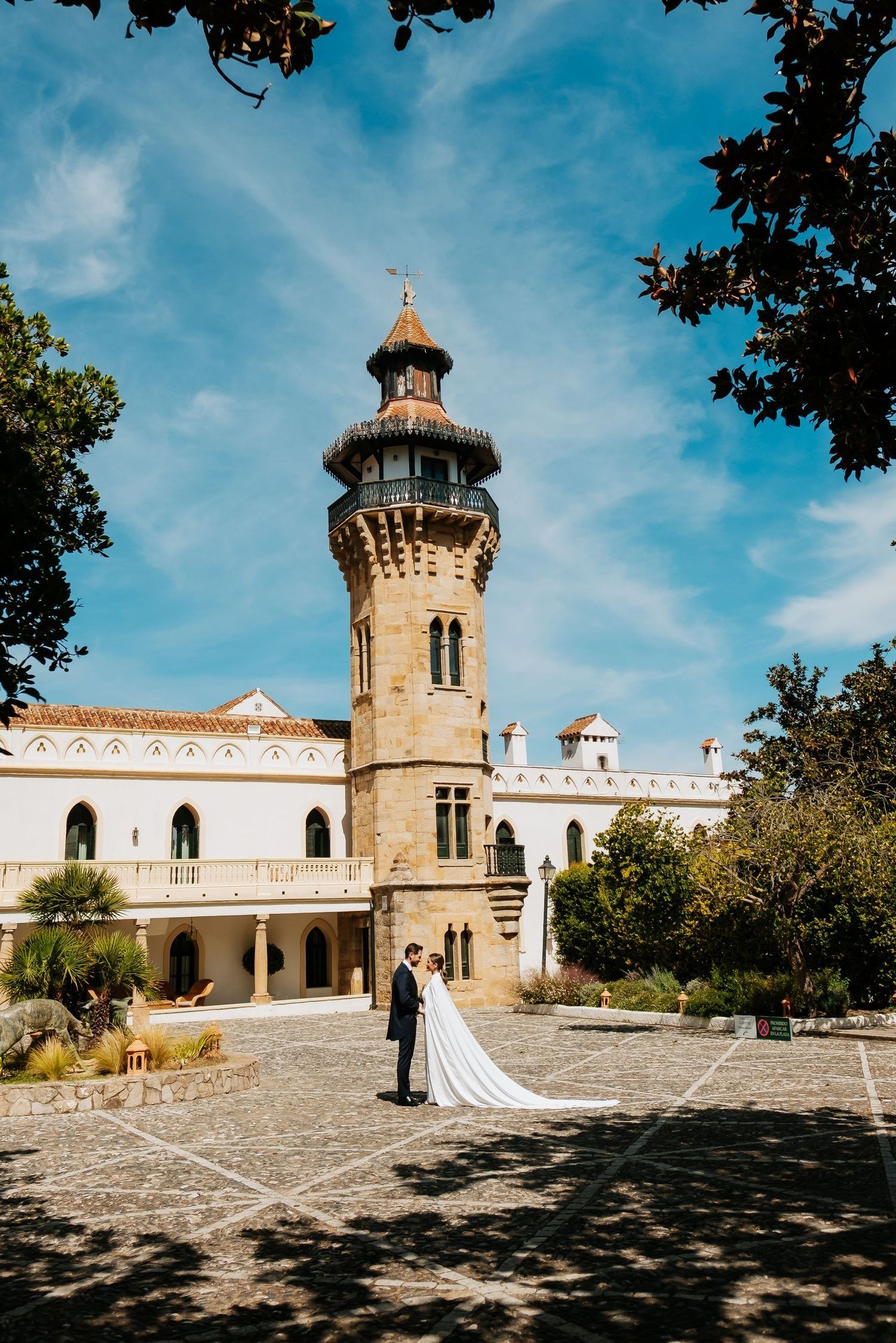 novios con la torre del convento de fondo al atardecer