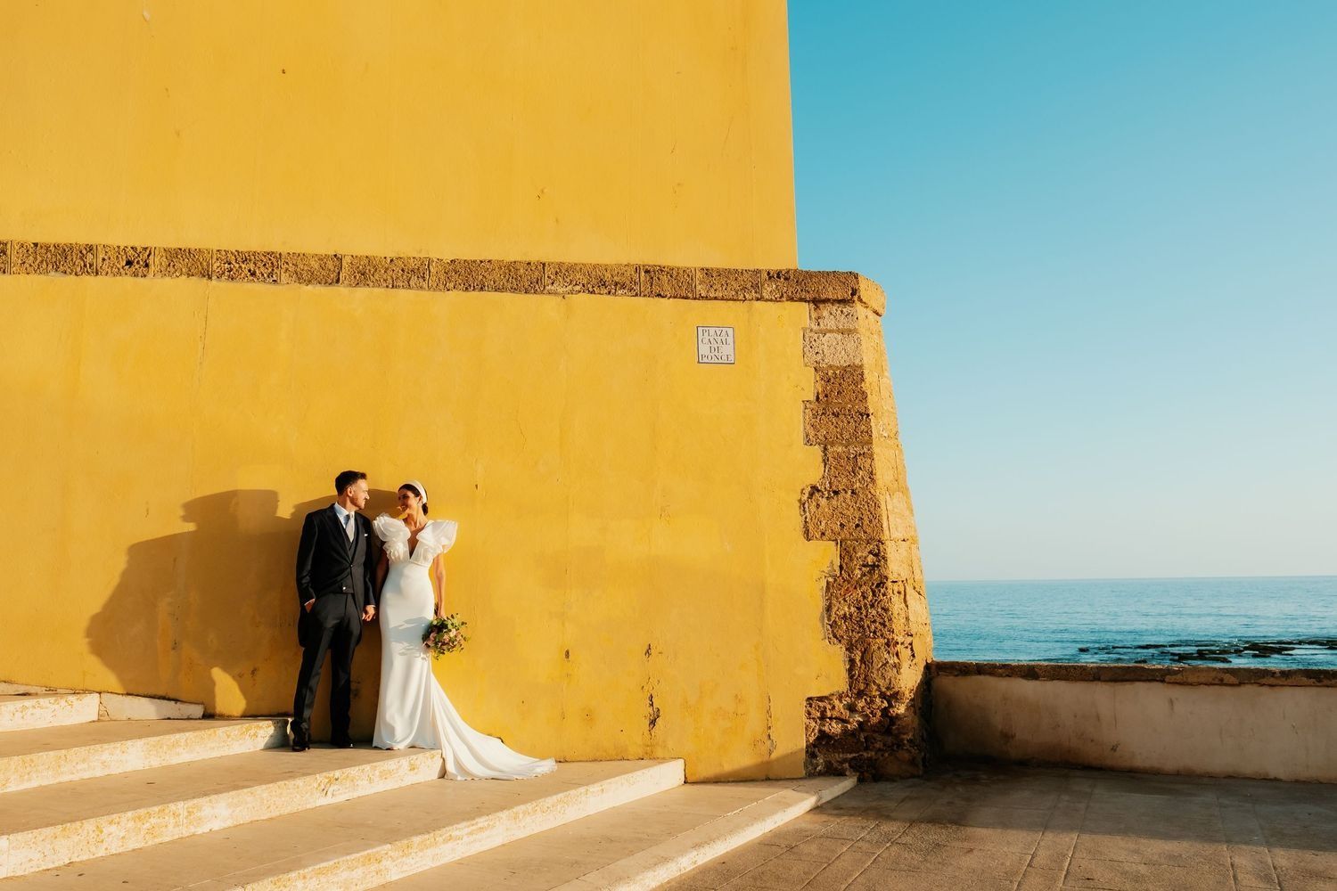 Siluetas de los novios con el sol poniéndose en el castillo de San Sebastián