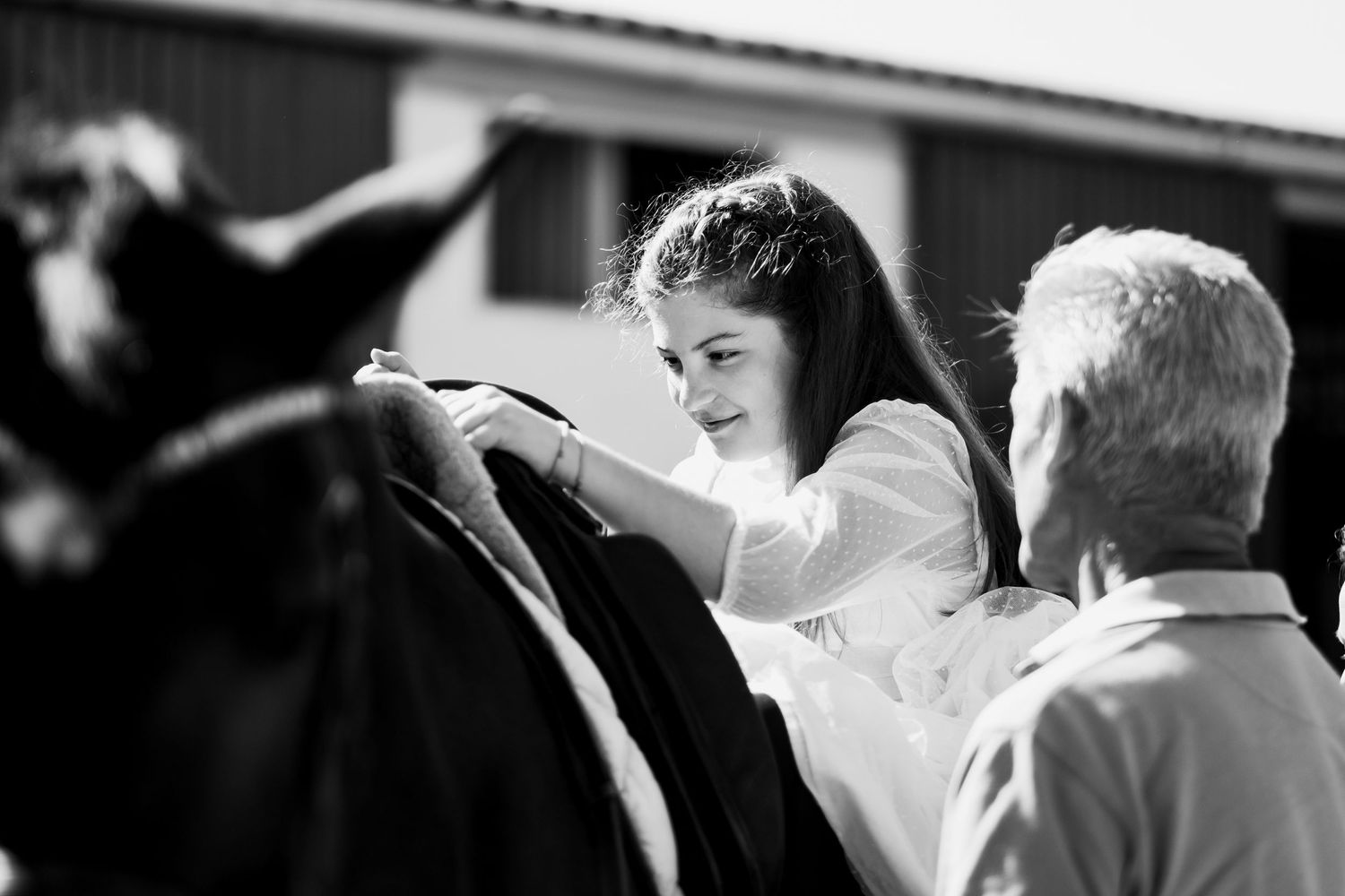 Paola preparando su caballo vestida de comunión
