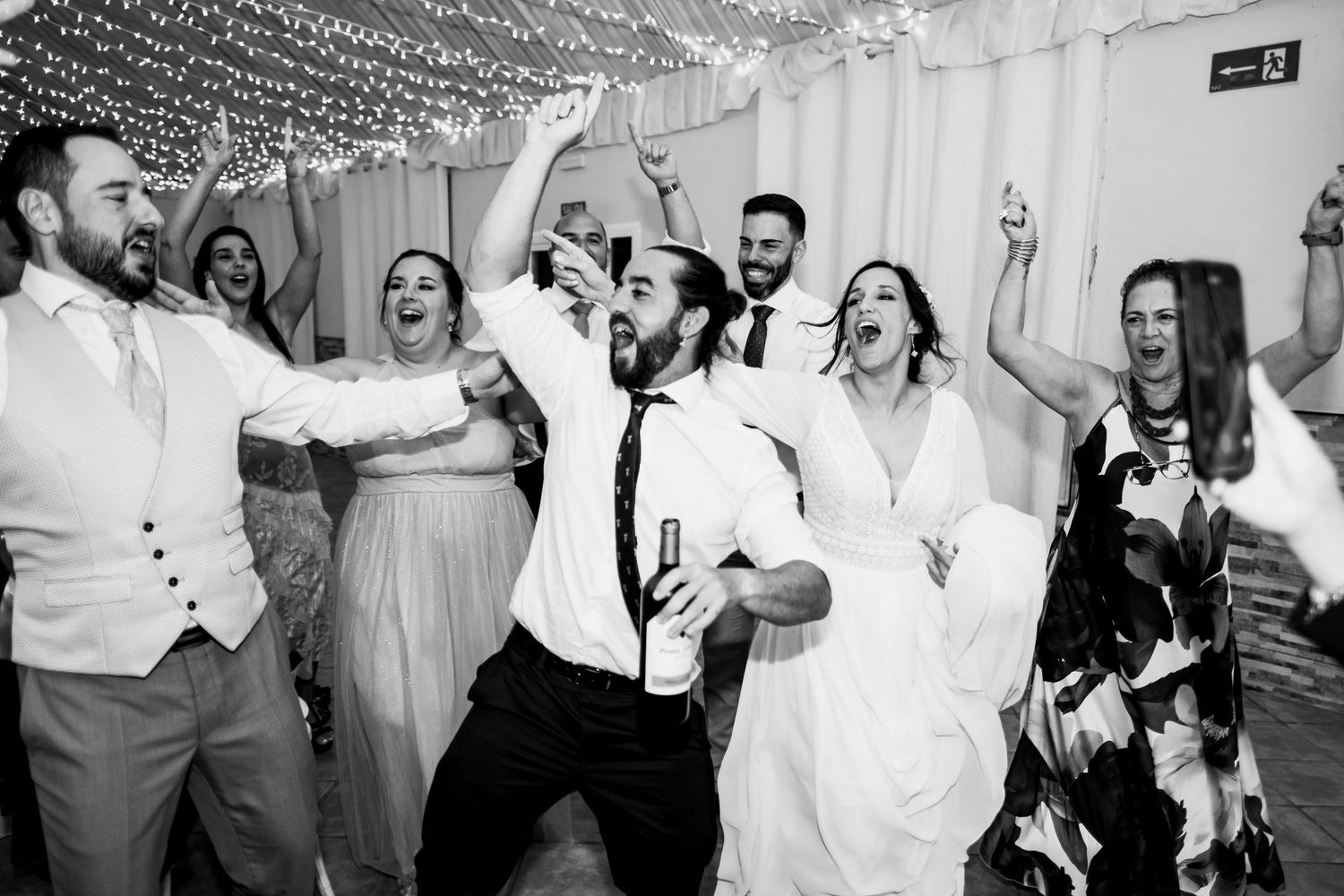 Black and white photos capturing candid dancing and celebration moments at a wedding reception.