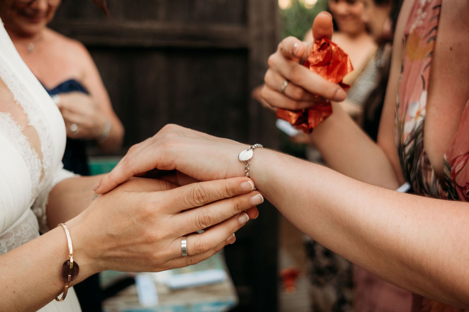 Detalle de las manos y del regalo a las damas de la boda